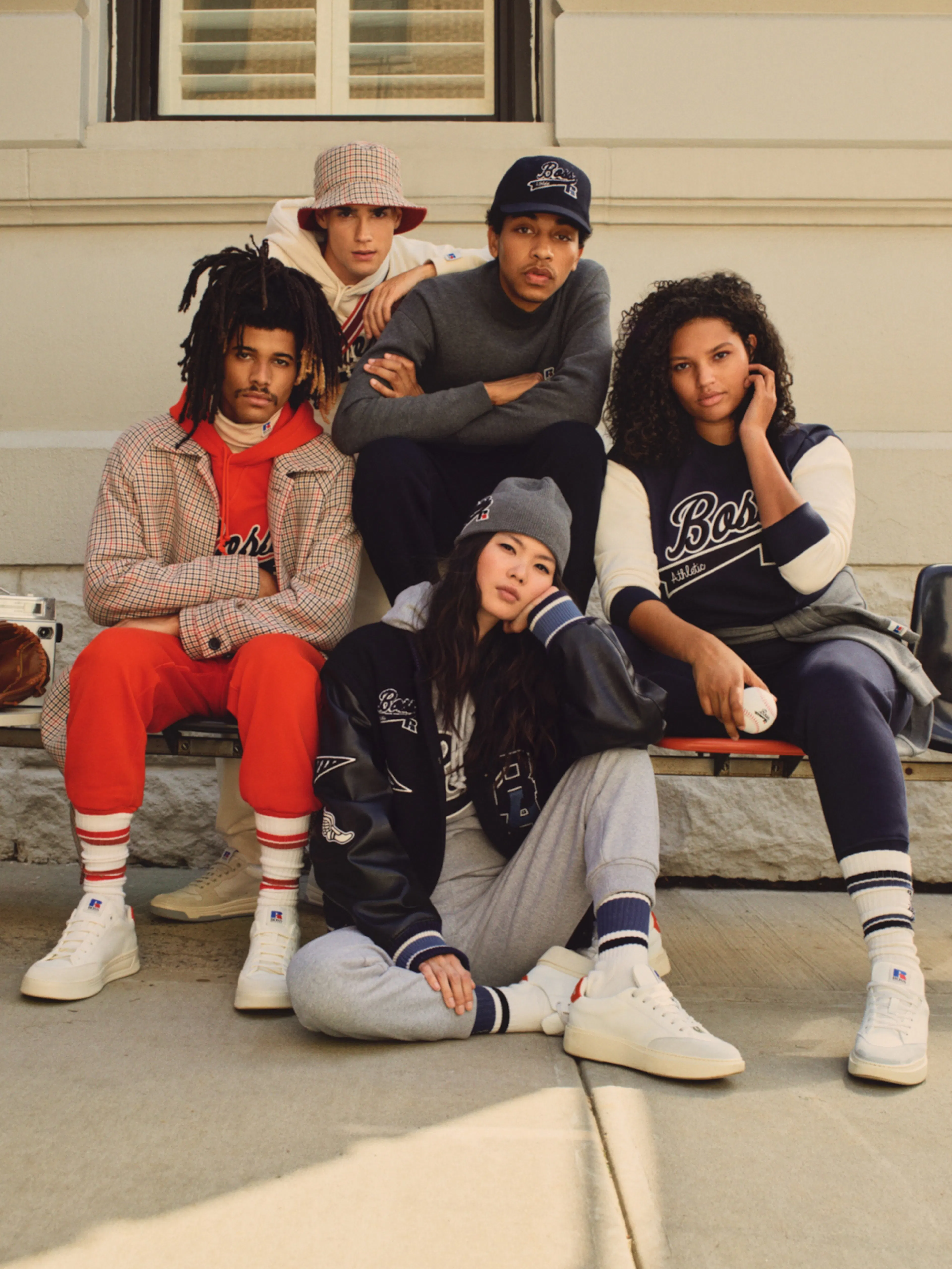 Hugo Boss – Campaign "Bringing Hugo Boss to the streets": Photo showing five young people in athletic-inspired fashion posing on a bench by HY.AM