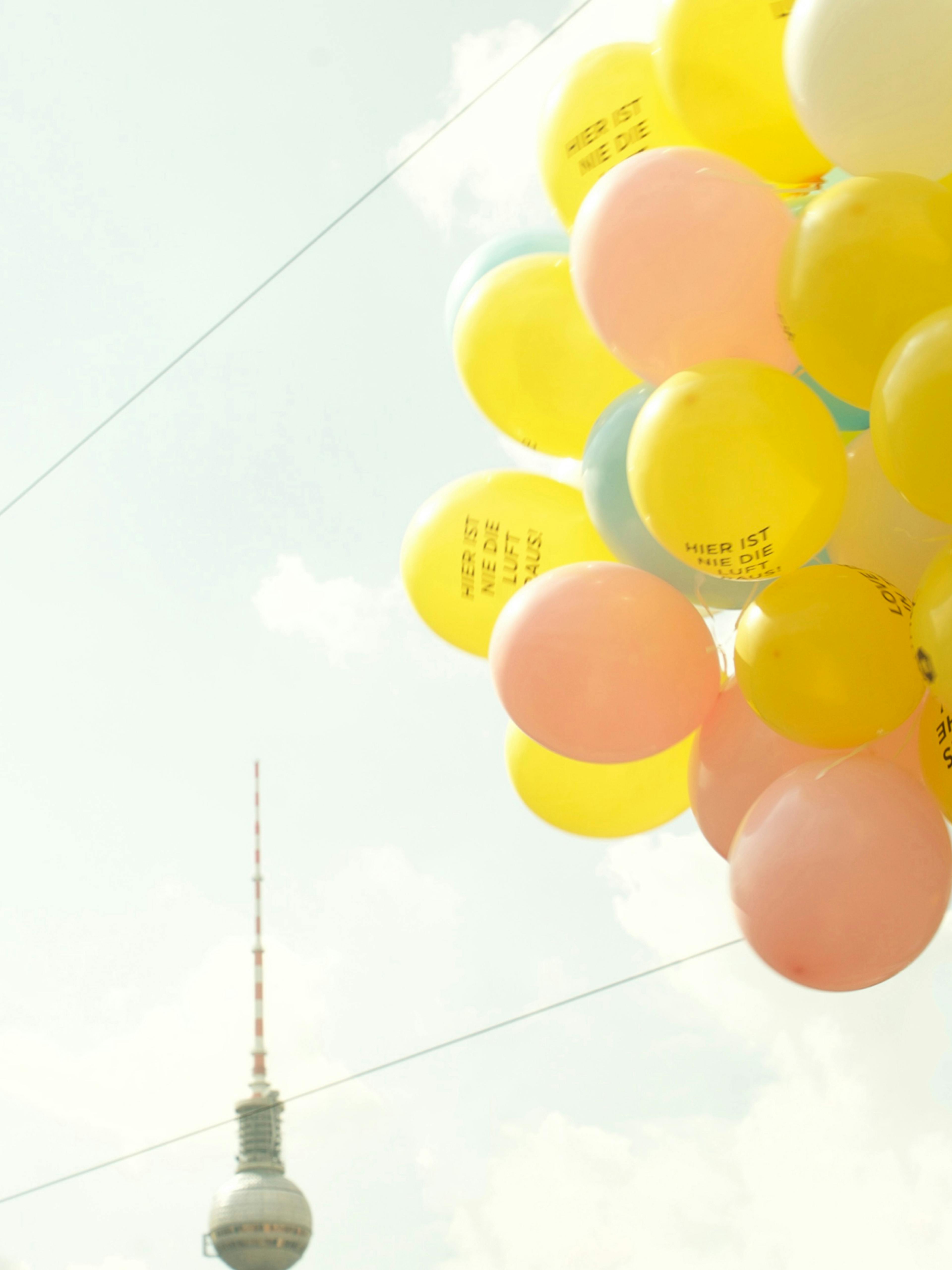 Bumble – Strategy & Brand Activation "Making the first move": Photo showing a cluster of yellow, pink, and light blue balloons against a bright sky, with the Berlin TV Tower visible in the background x HY.AM Studios