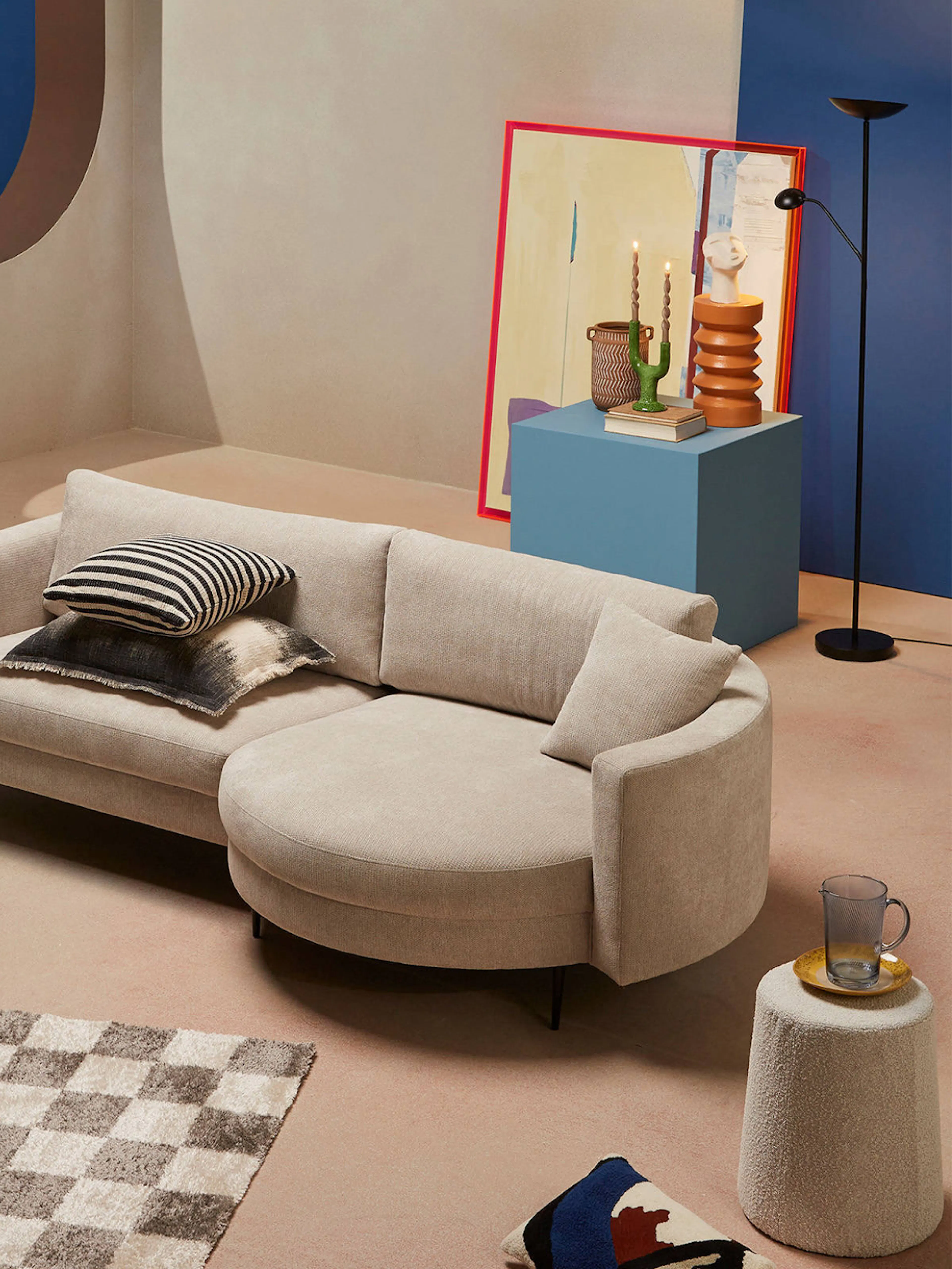 Wehkamp – Brand Design, E-Commerce, Experience Design "Ecommerce reimagined": Photo showing a modern living room setup with a curved sofa, abstract art, and decorative objects x HY.AM Studios