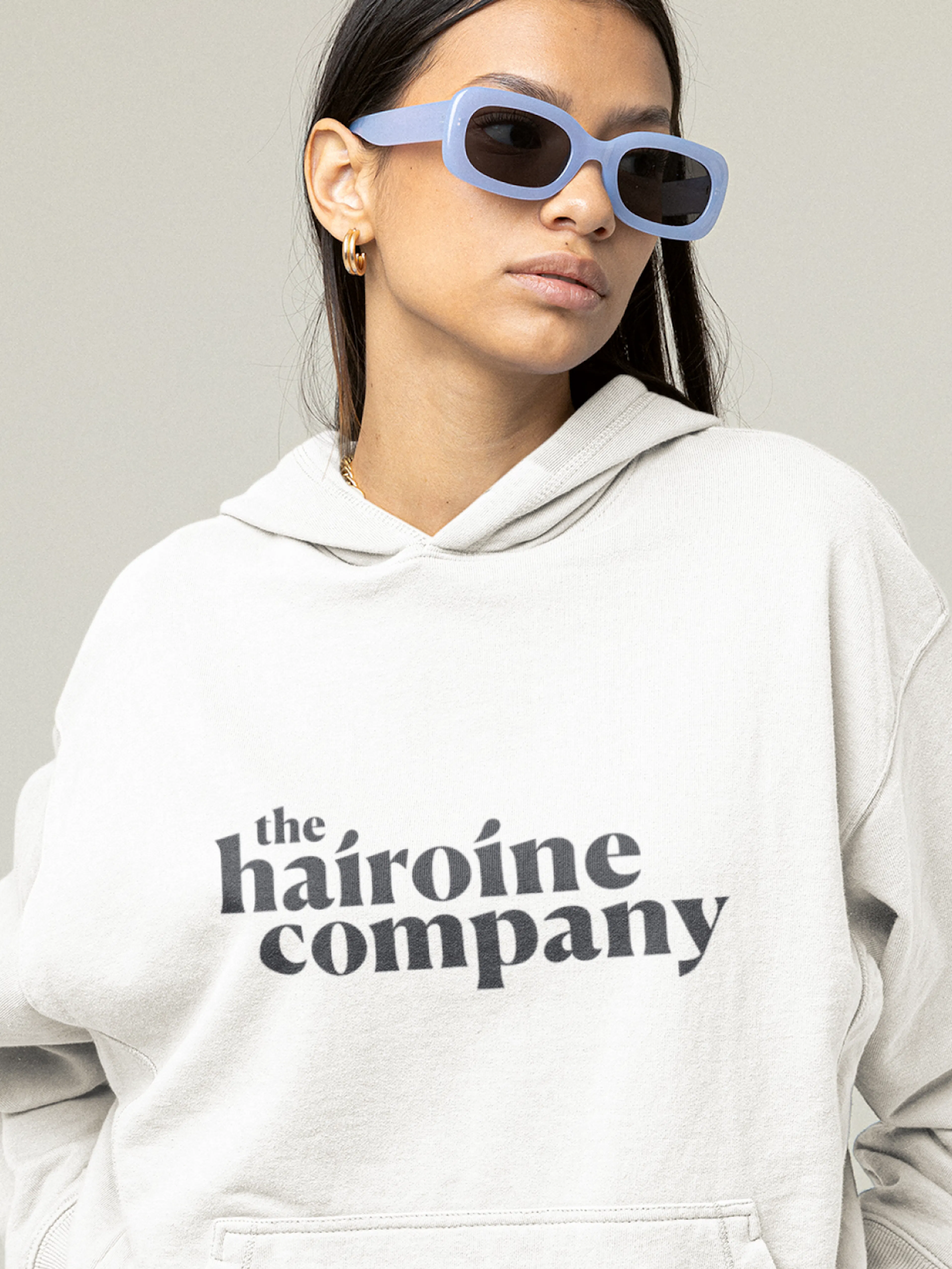 The Hairoine Company – Branding "A hair care brand for confident women": Mockup showing a woman wearing a hoodie with the brand logo by HY.AM