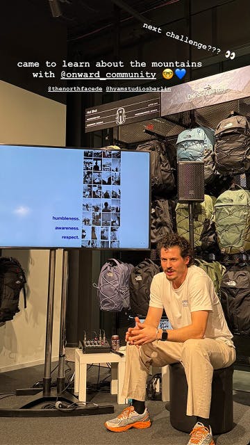 The North Face – Brand Activation "Summit Series Brand Activation": Photo showing a man sitting in front of a screen displaying photos and text, with backpacks on display behind him x HY.AM Studios