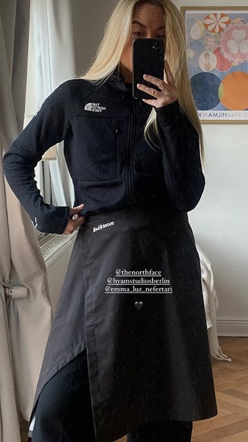 The North Face – Brand Activation "Summit Series Brand Activation": Photo showing a woman in a black North Face jacket and a black wrap skirt, taking a selfie x HY.AM Studios