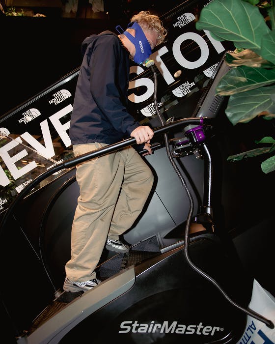 The North Face – Brand Activation "Summit Series Brand Activation": Photo showing a person wearing a blue mask and climbing a StairMaster with The North Face branding x HY.AM Studios