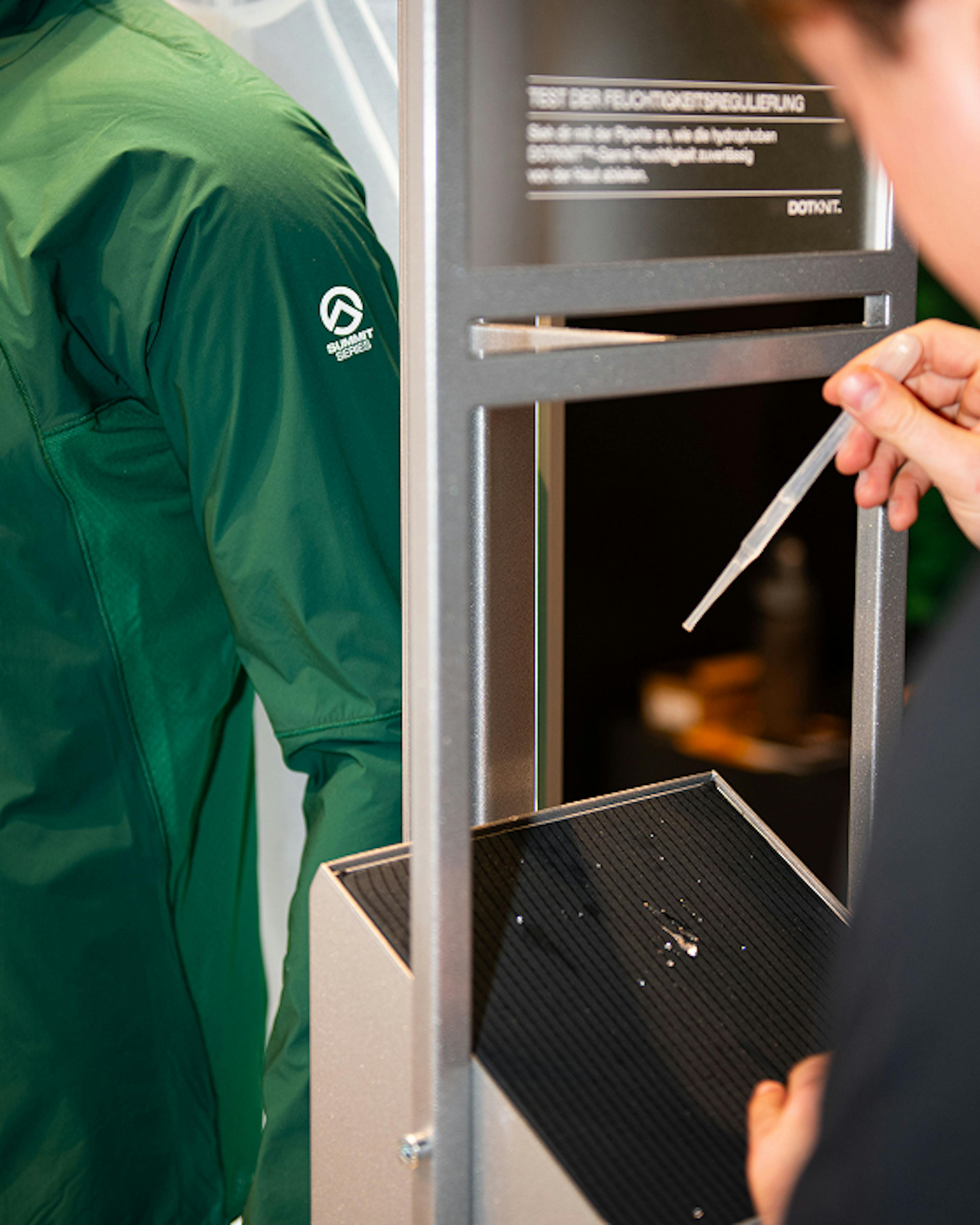 The North Face – Brand Activation "Summit Series Brand Activation": Photo showing a green jacket with the Summit Series logo and a person testing fabric breathability x HY.AM Studios