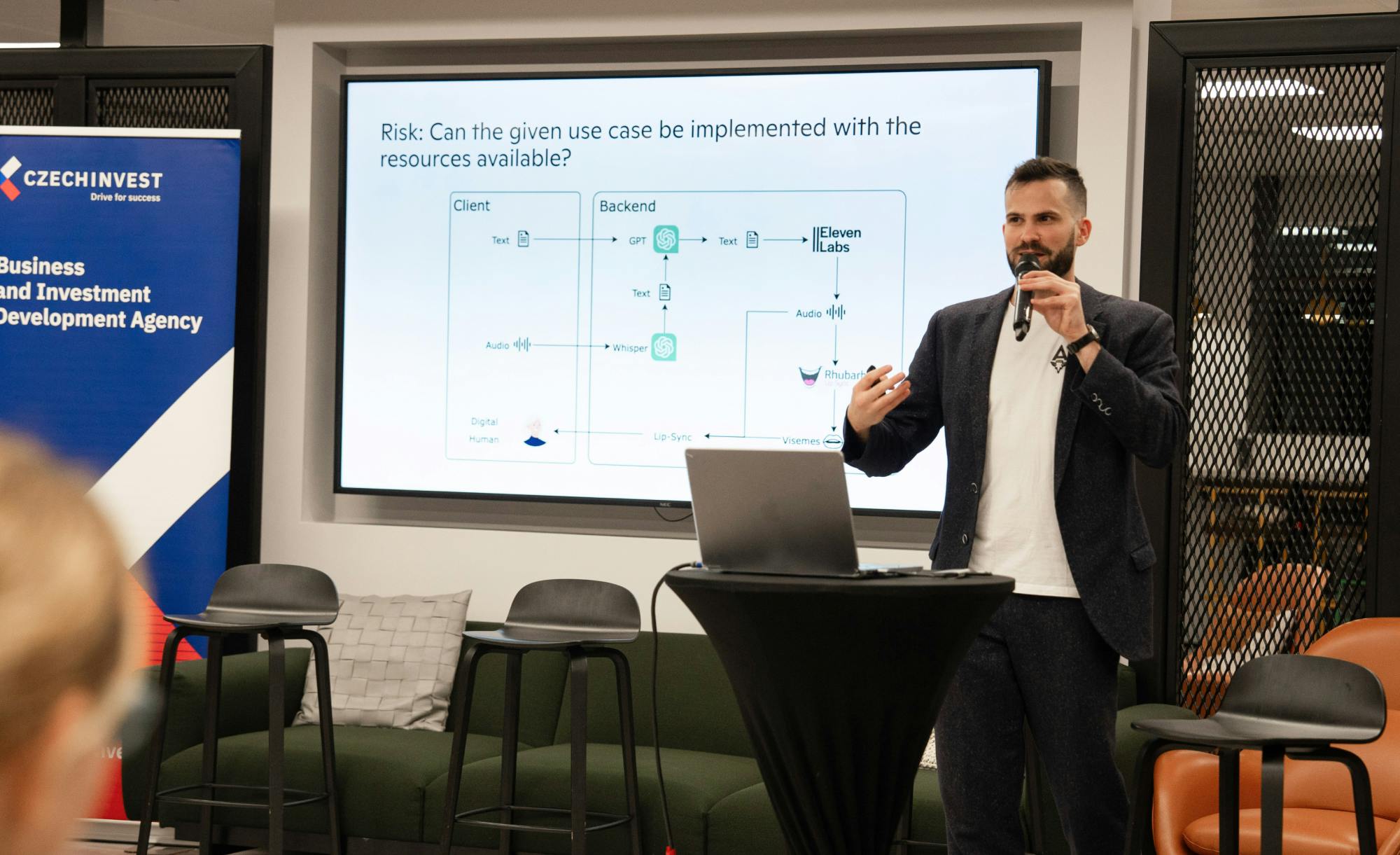 Expert Jan Cerny discussing AI implementation risks and resource feasibility during an event, featuring a detailed technical diagram and practical insights on AI use cases