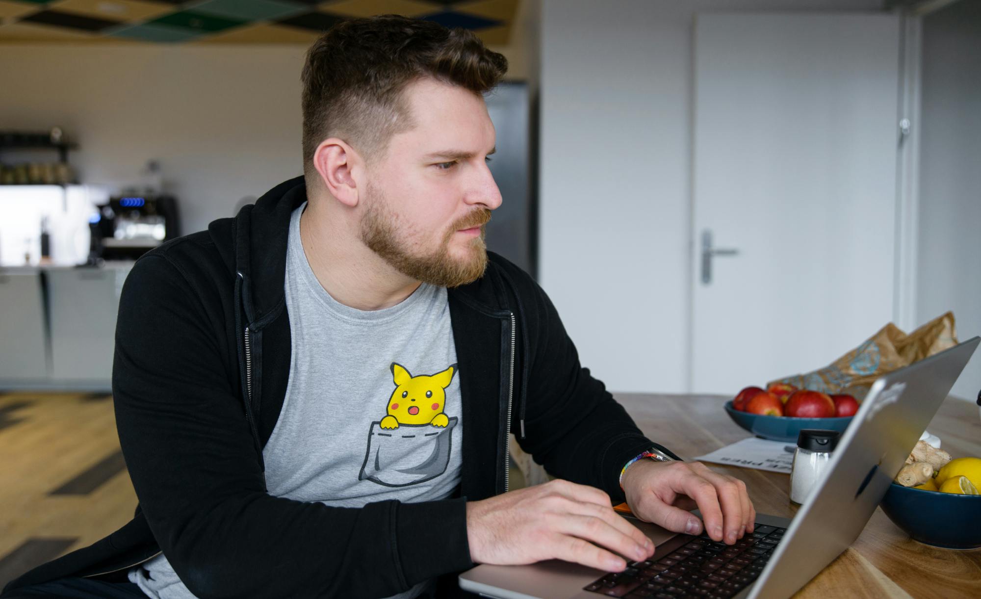 Co-founder Filip working on a laptop in a casual office setting wearing a Pikachu t-shirt.