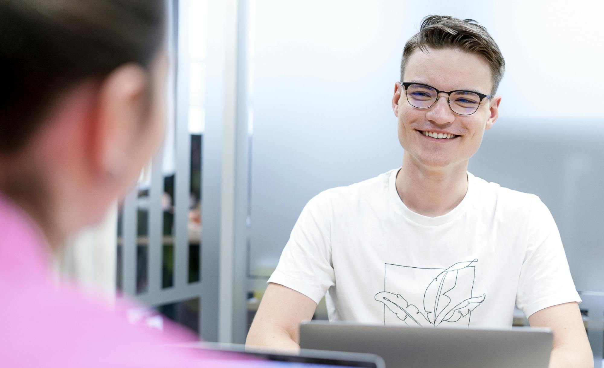 marketing specialist smiling at his blurry colleague in the foreground