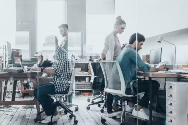 Image shows 4 people working in a office.