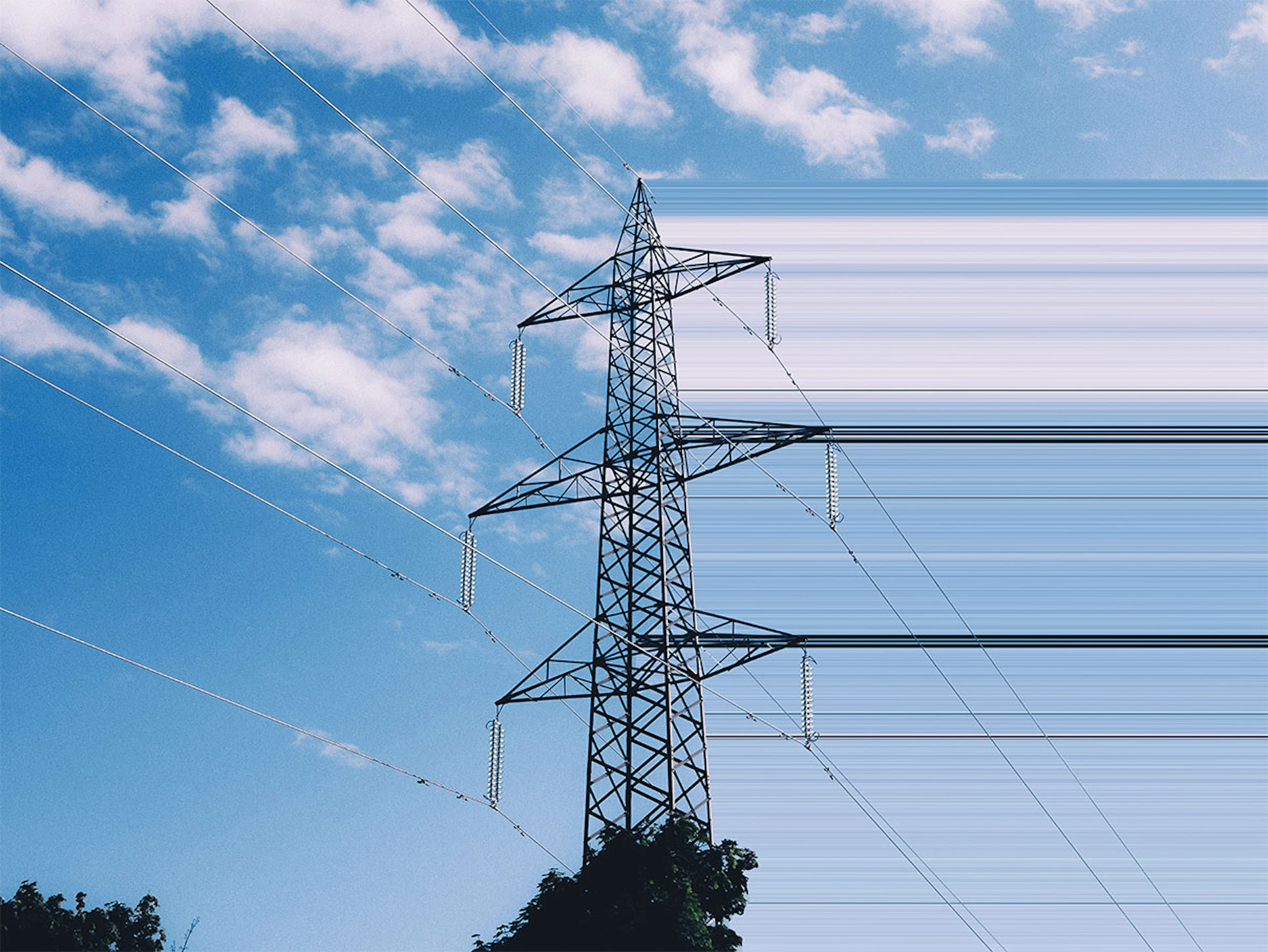 High-voltage electricity transmission tower against a partly cloudy blue sky