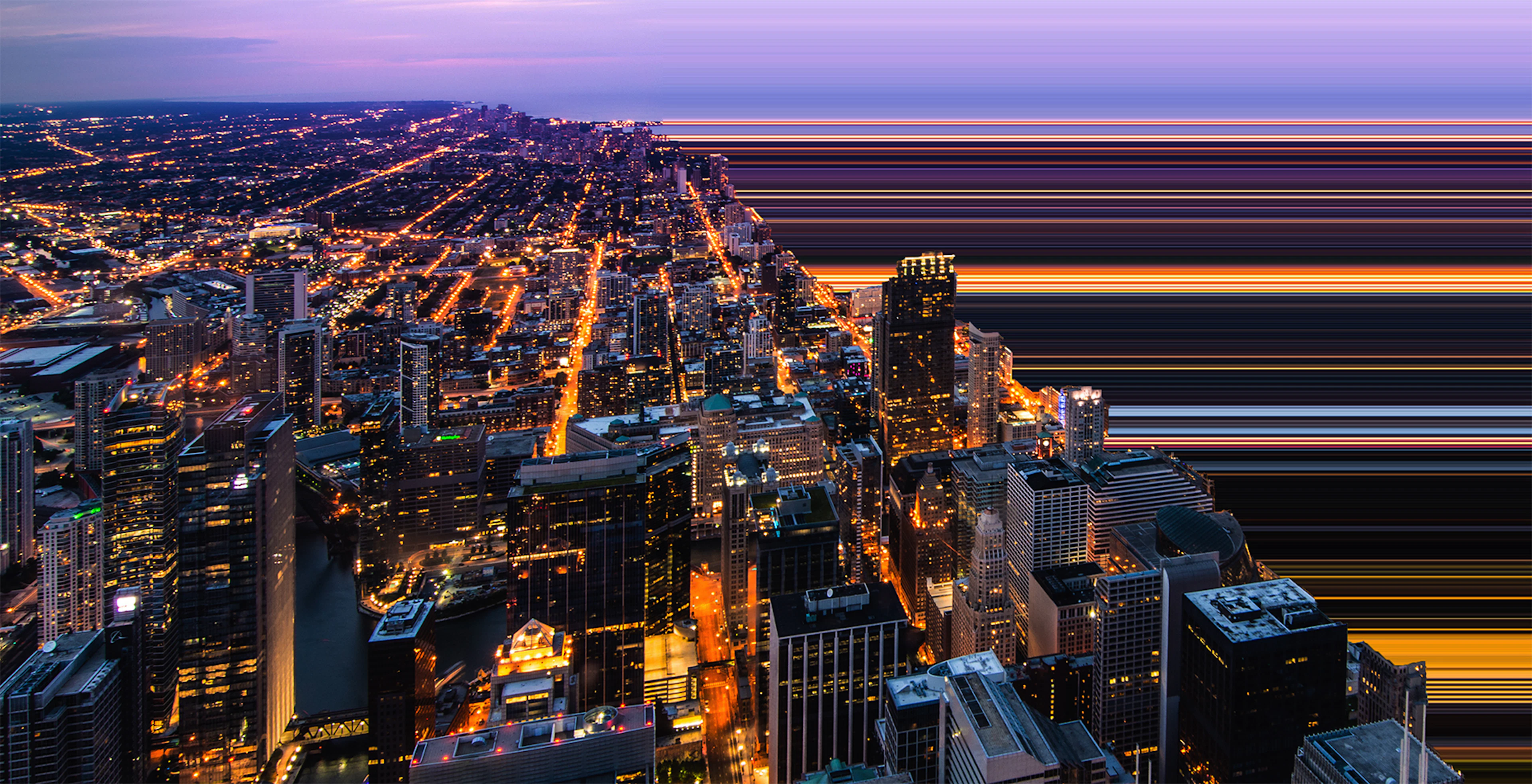 Aerial view of city grid next to water at night