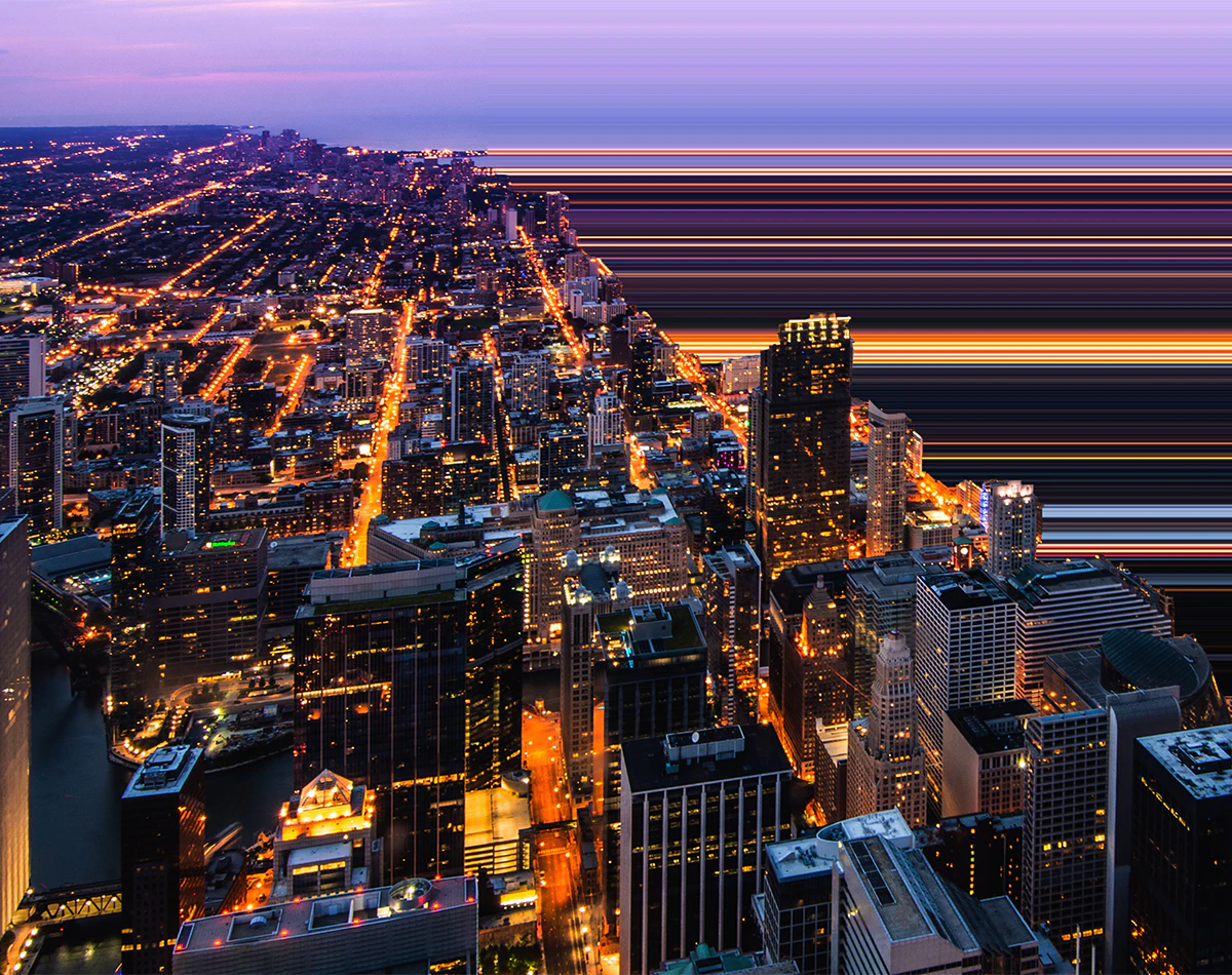 Aerial view of city grid next to water at night