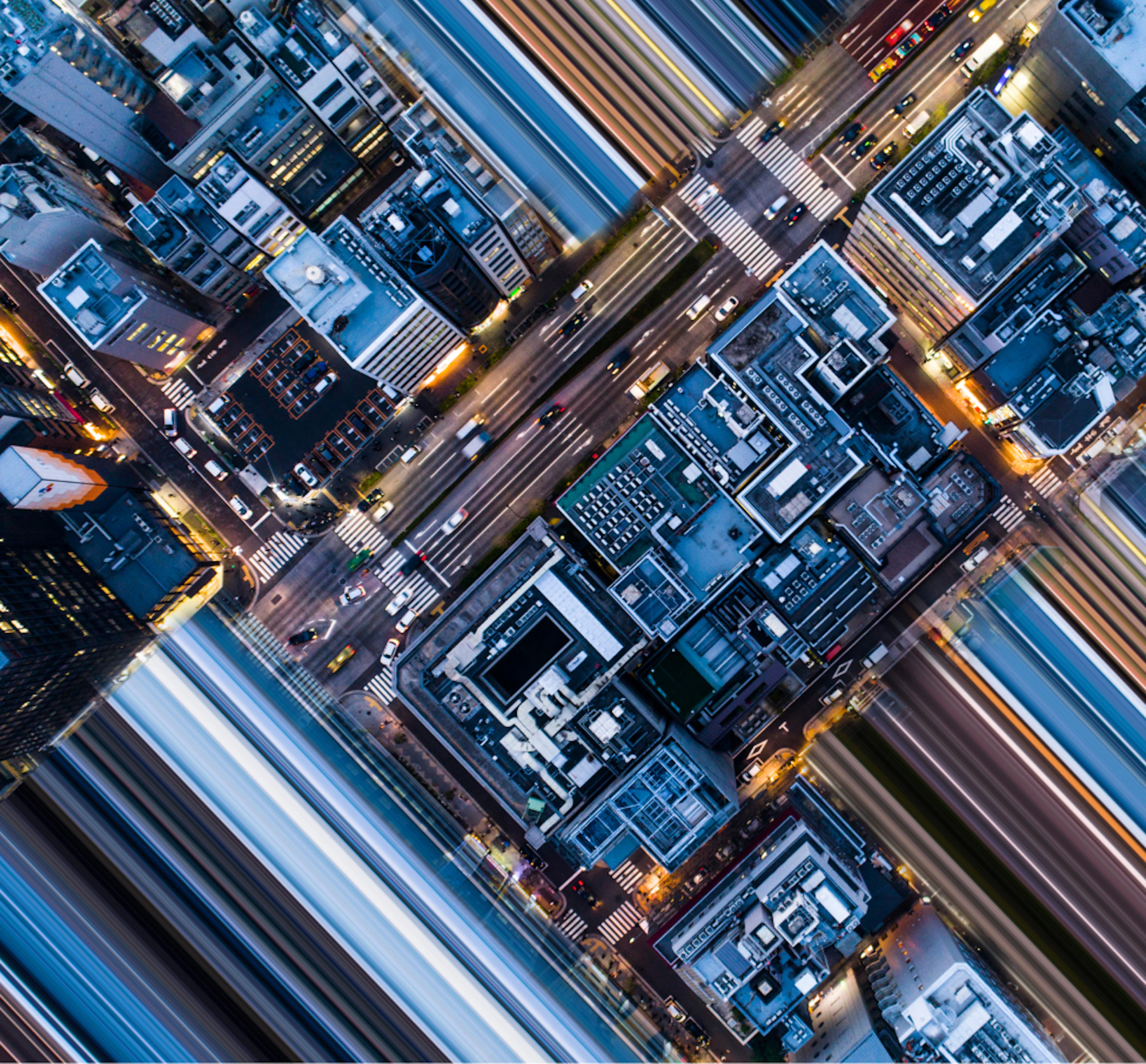 Aerial downward view of a dense city center with illuminated streets at night