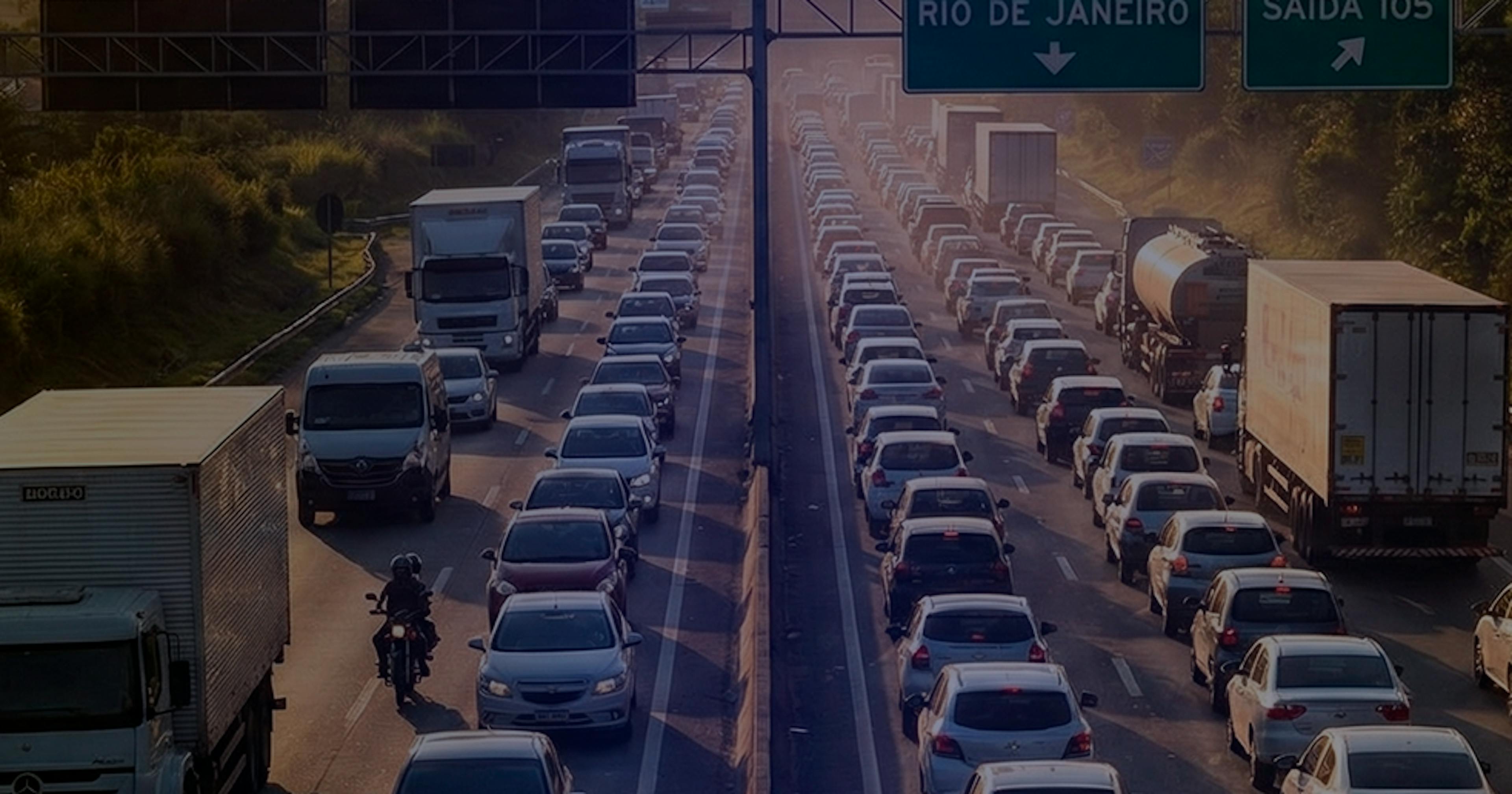 Vista aérea de um pátio logístico com vários caminhões estacionados lado a lado, enquanto trabalhadores fazem o carregamento de cargas em caminhões baú abertos.