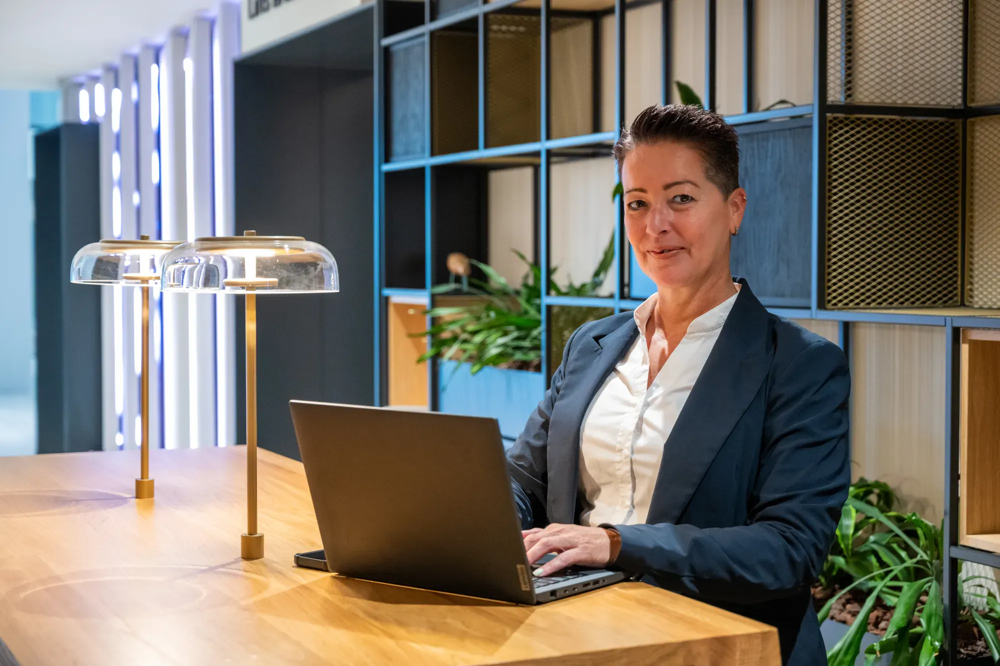 Vrouw lachend achter laptop