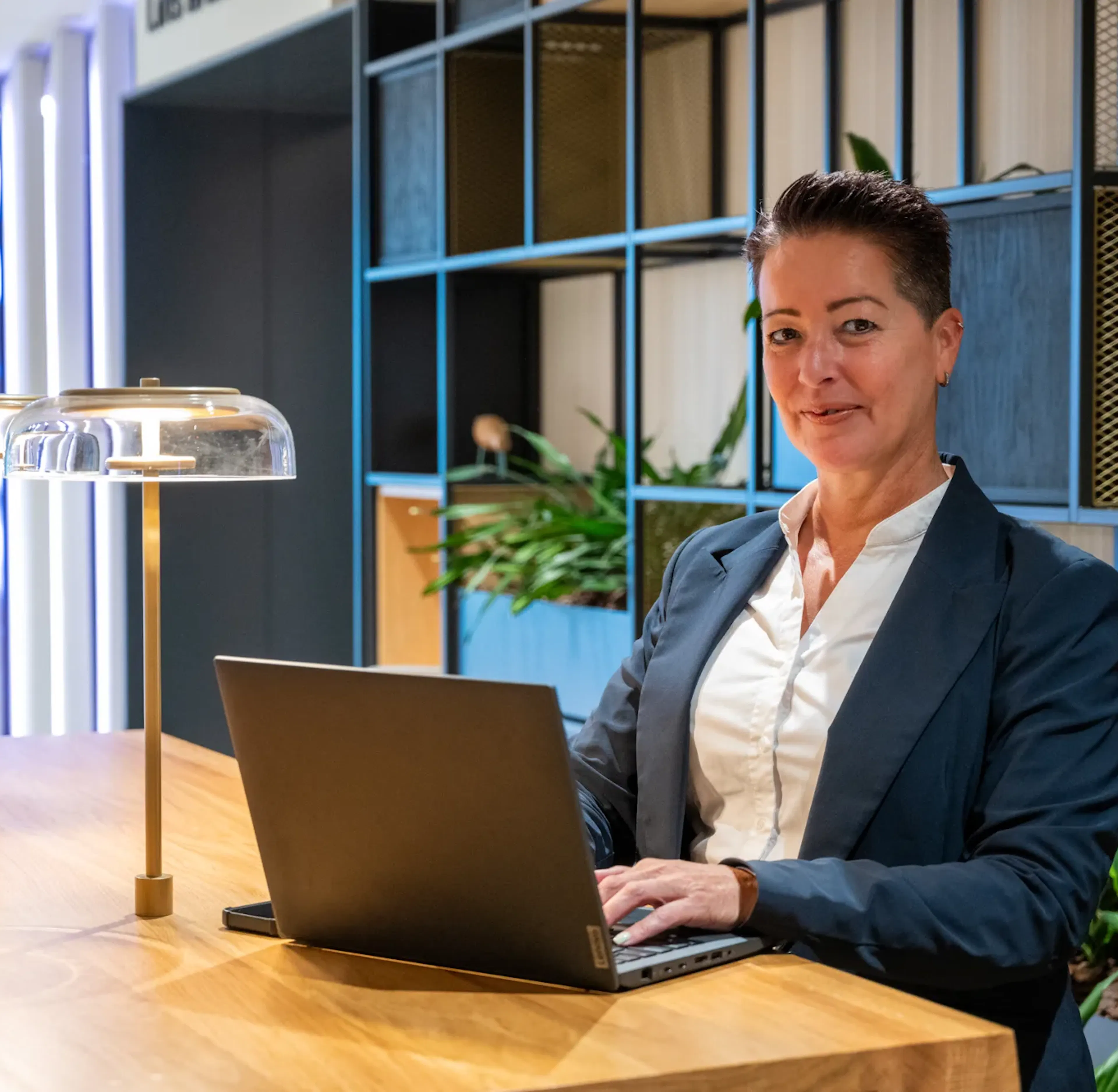Vrouw lachend achter laptop