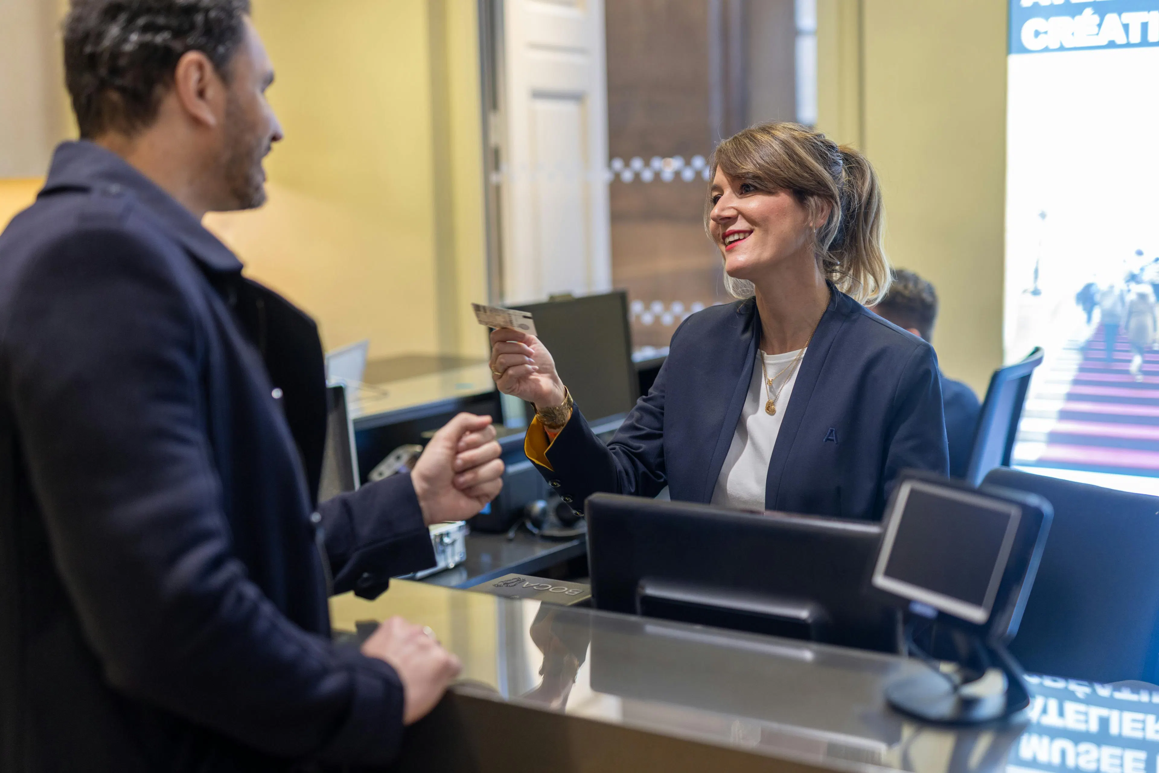 A front desk agent in a museum giving information to visitors