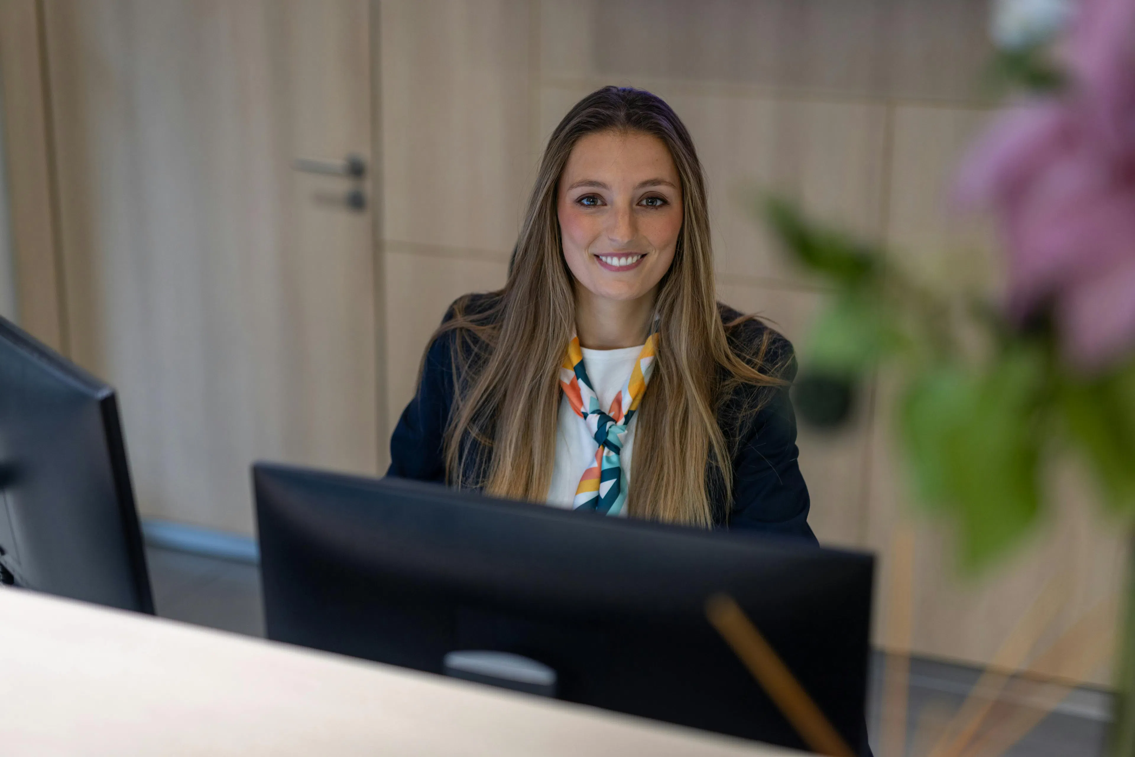 A receptionist smiling at her computer