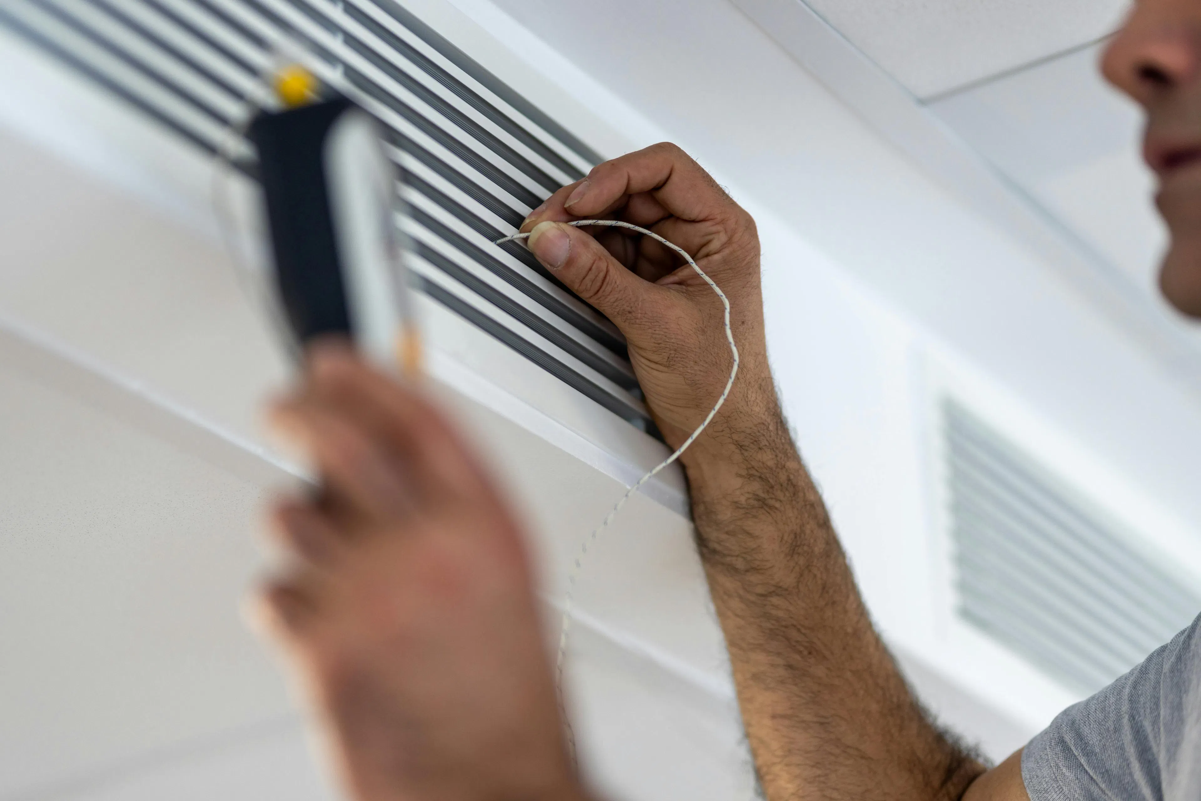 A maintenance technician repairing an air conditioning unit