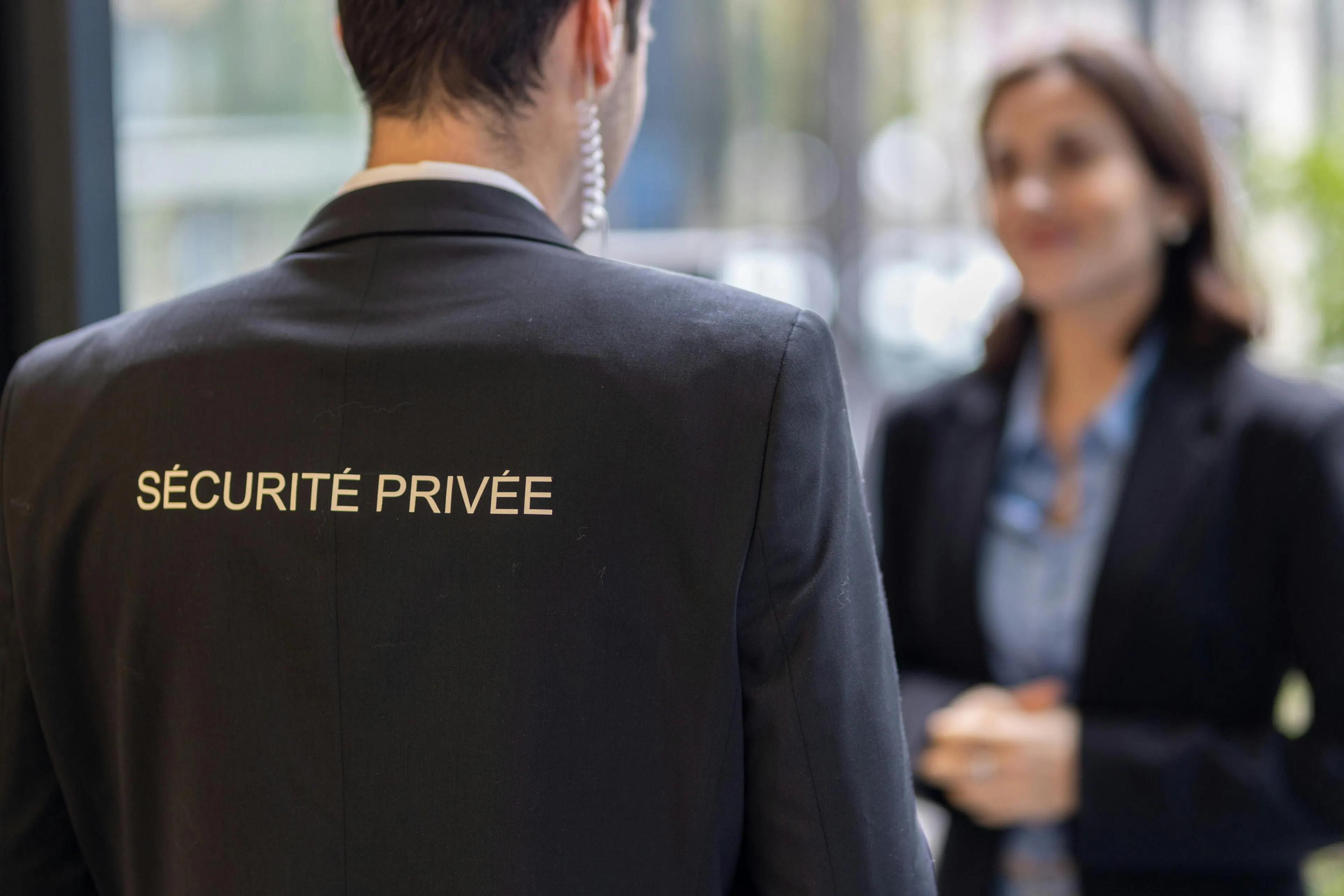 A security guard checking the identity of an employee at a building entrance