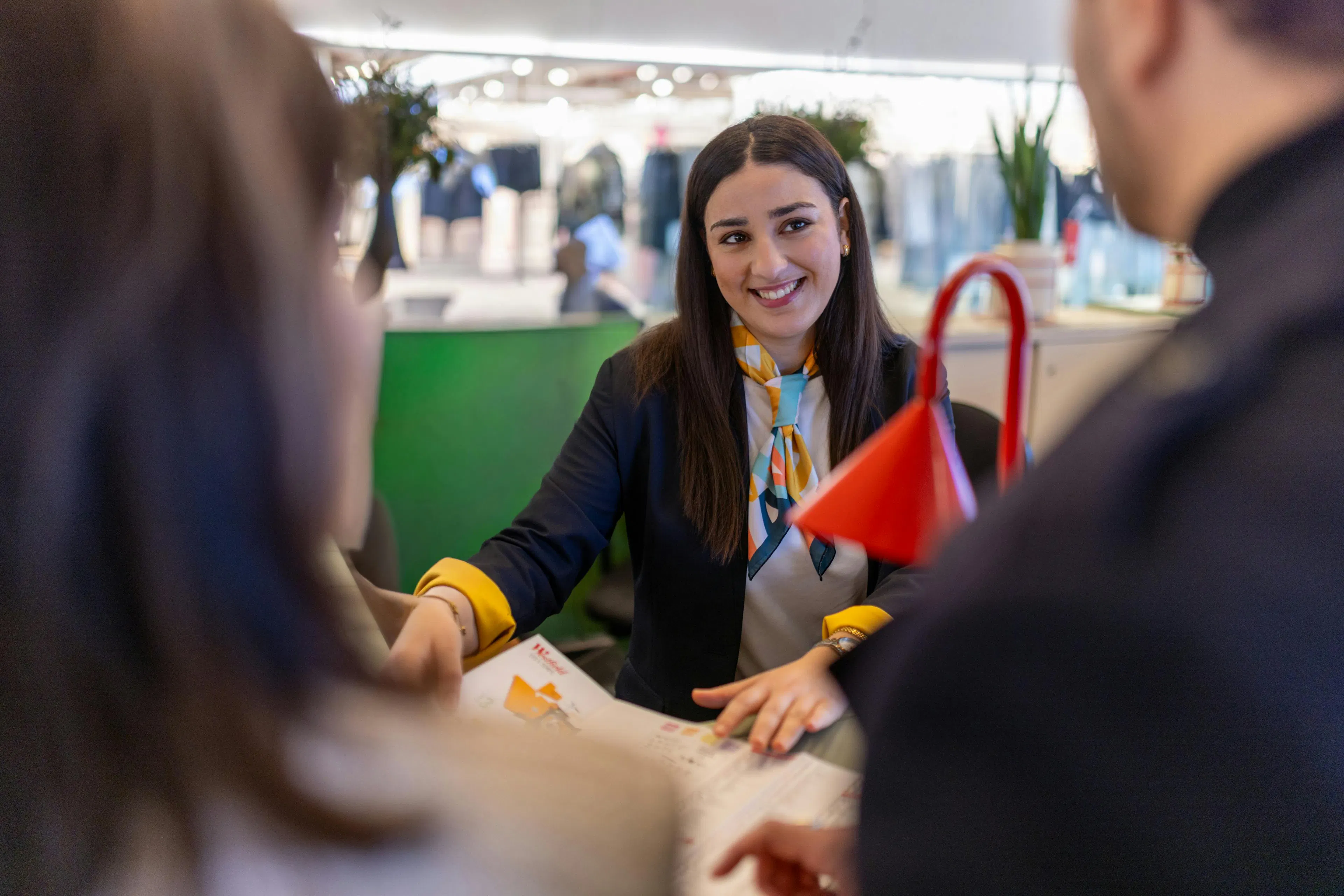 A hostess providing orientation information about the shopping center to a visitor