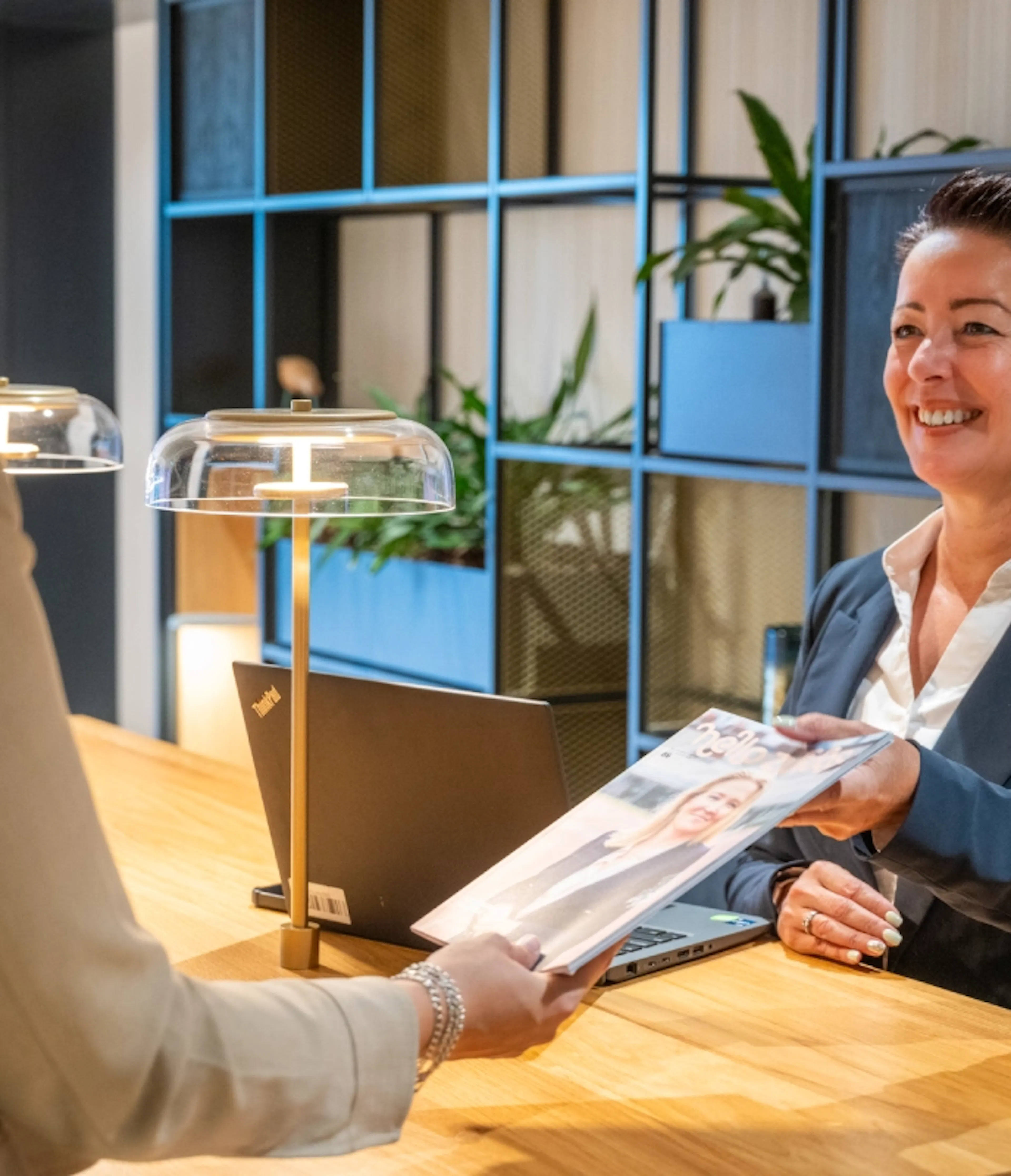 Een hostess overhandigt een magazine