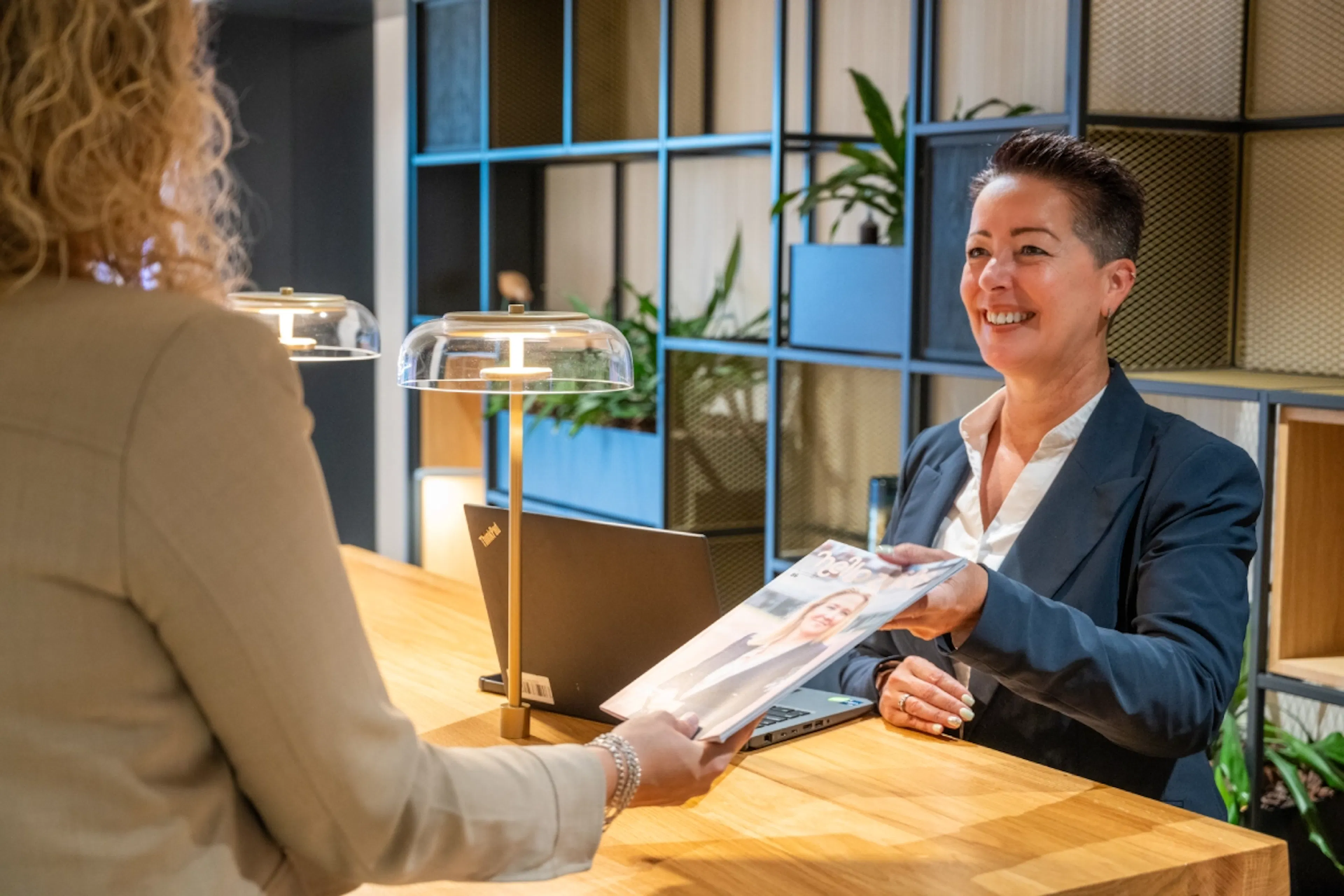 Een hostess overhandigt een magazine