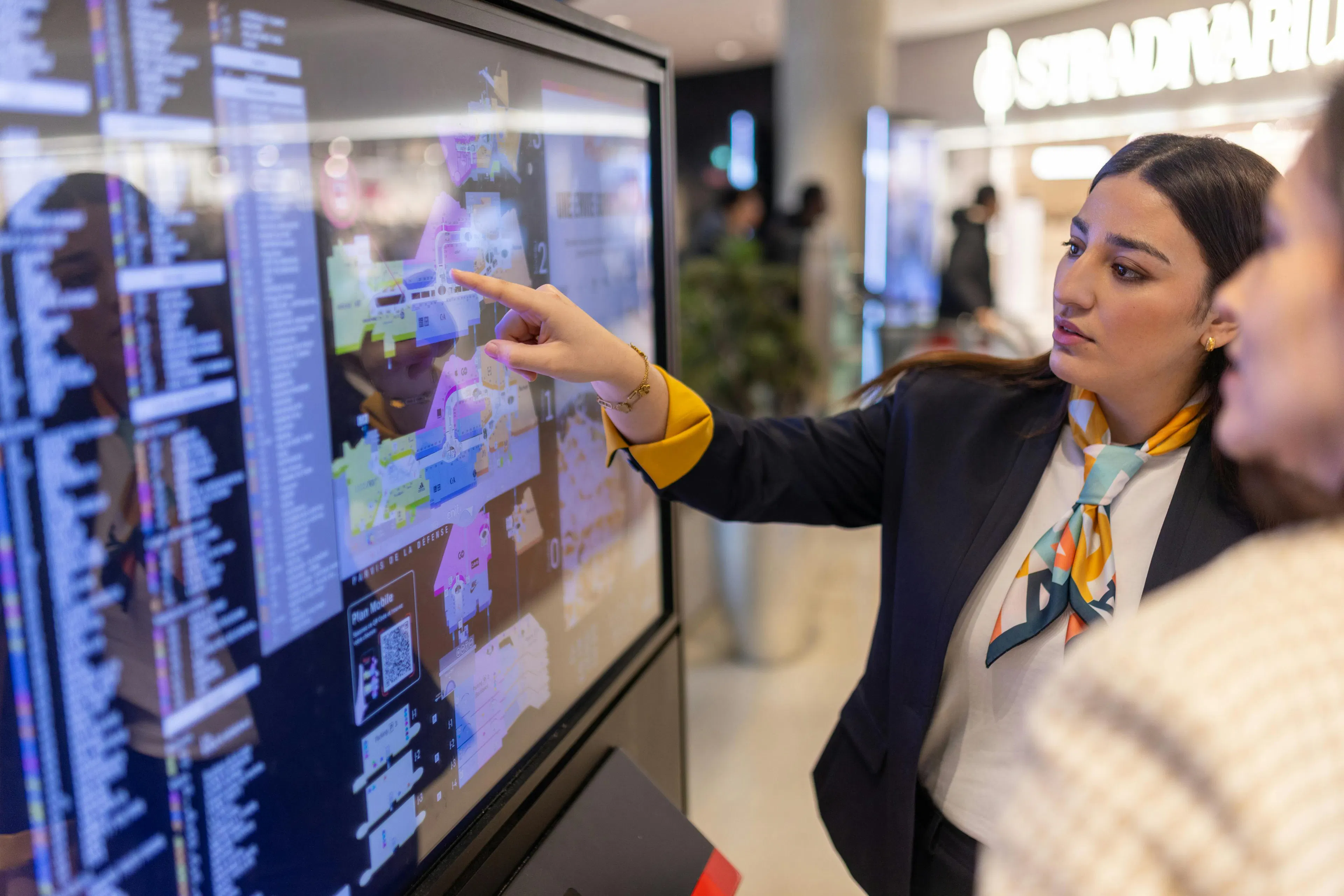A hostess providing orientation information about the shopping center to a visitor
