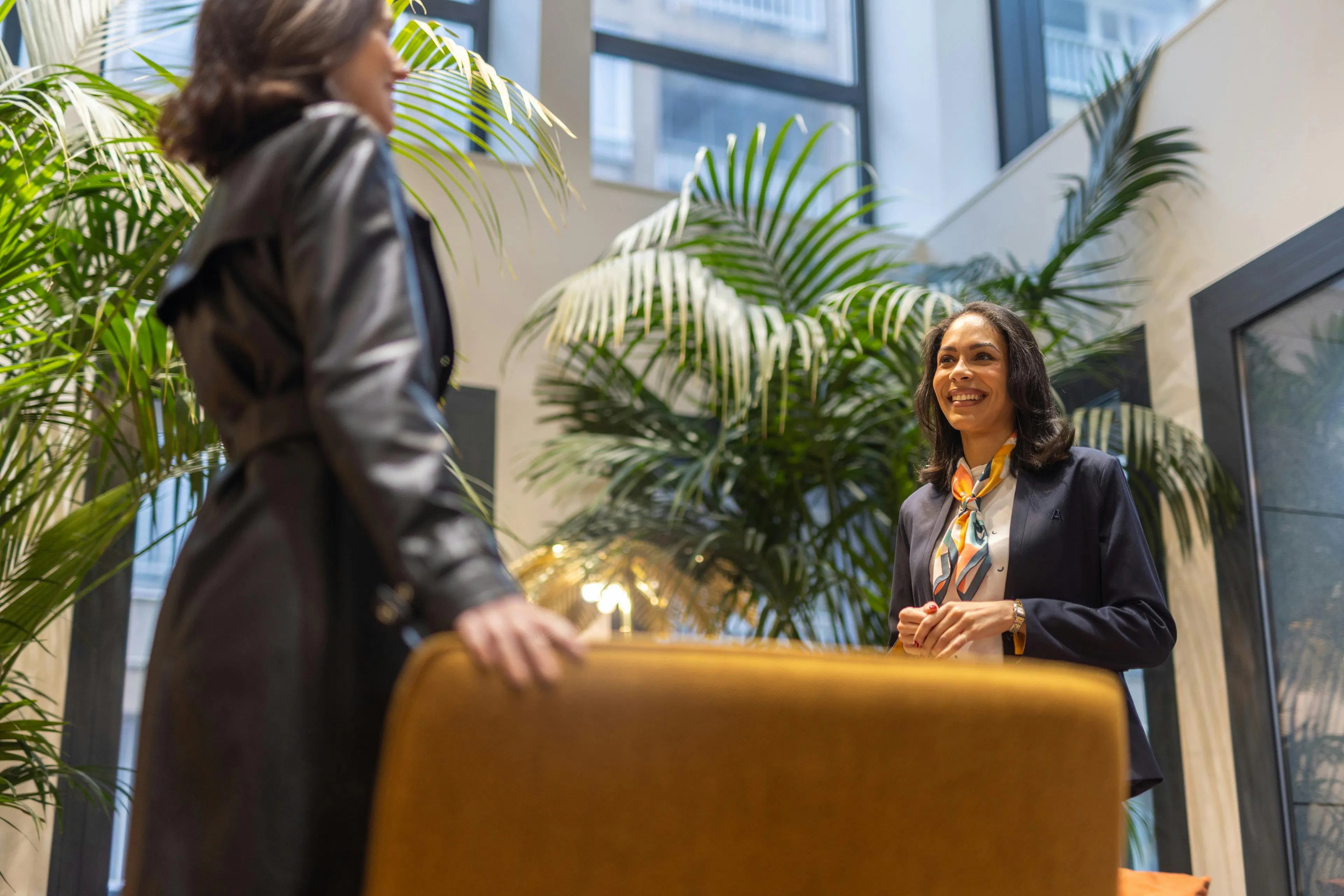 A hostess welcoming a visitor in a work environment