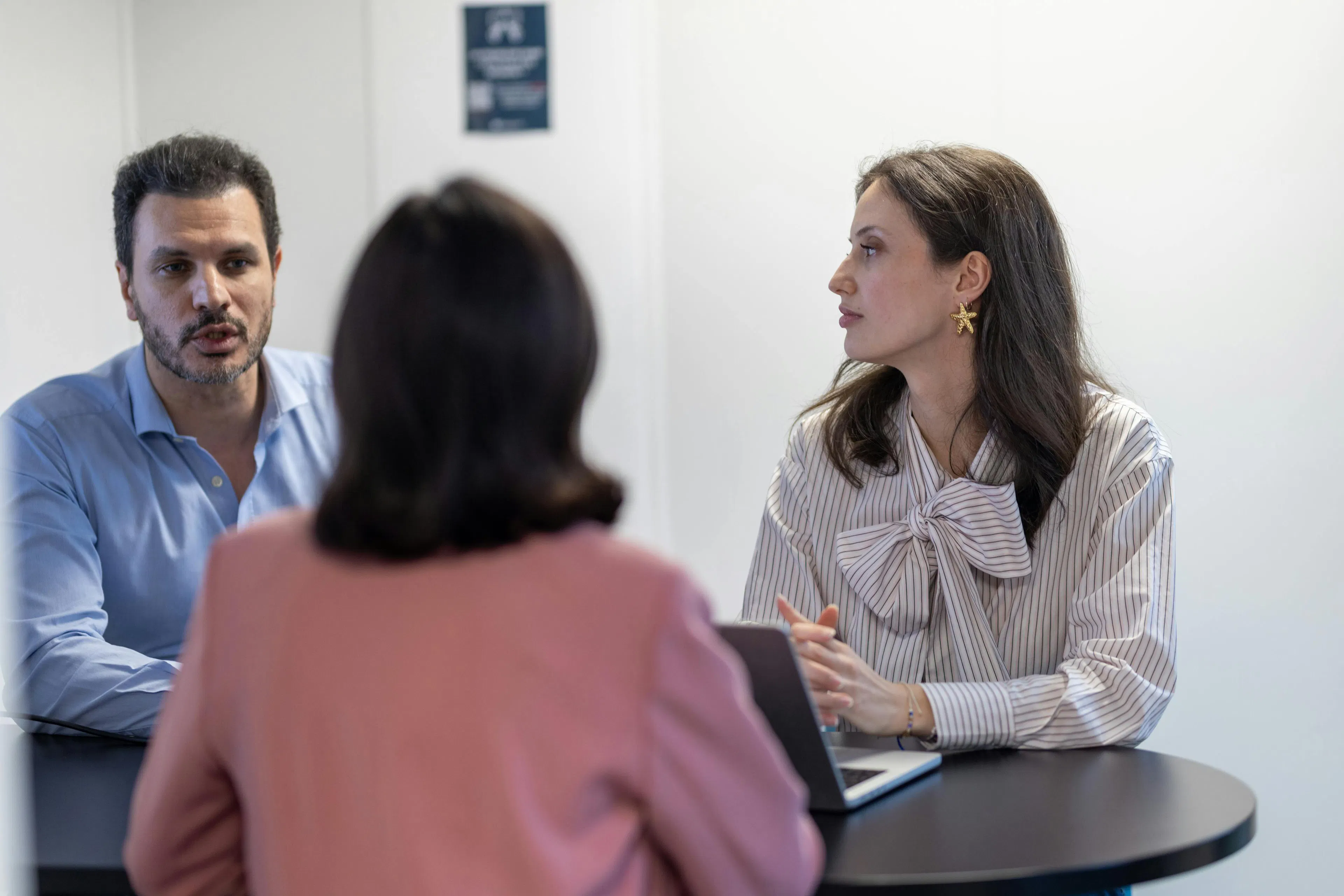 Three colleagues exchanging during a professional meeting