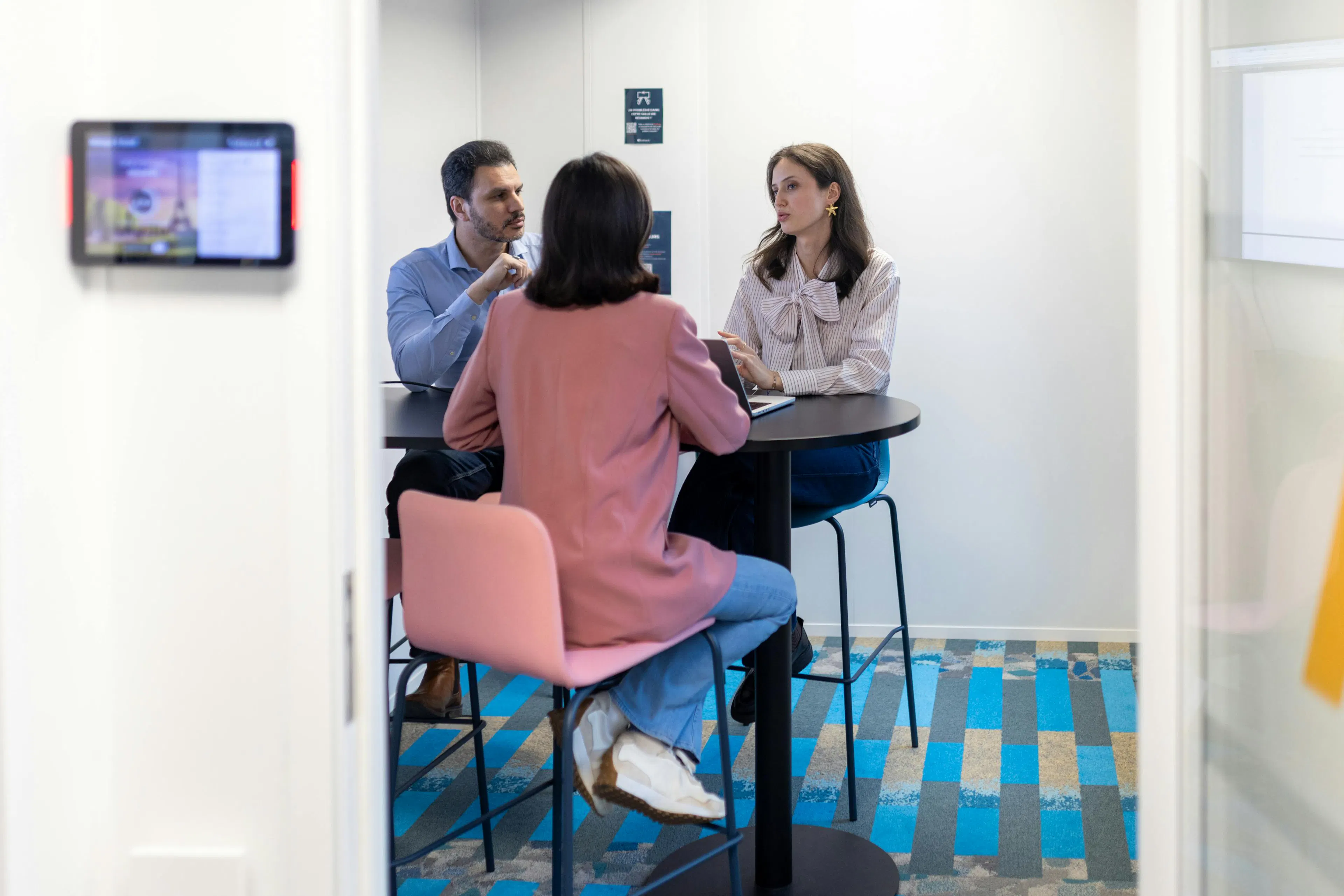 Drie medewerkers in gesprek met elkaar