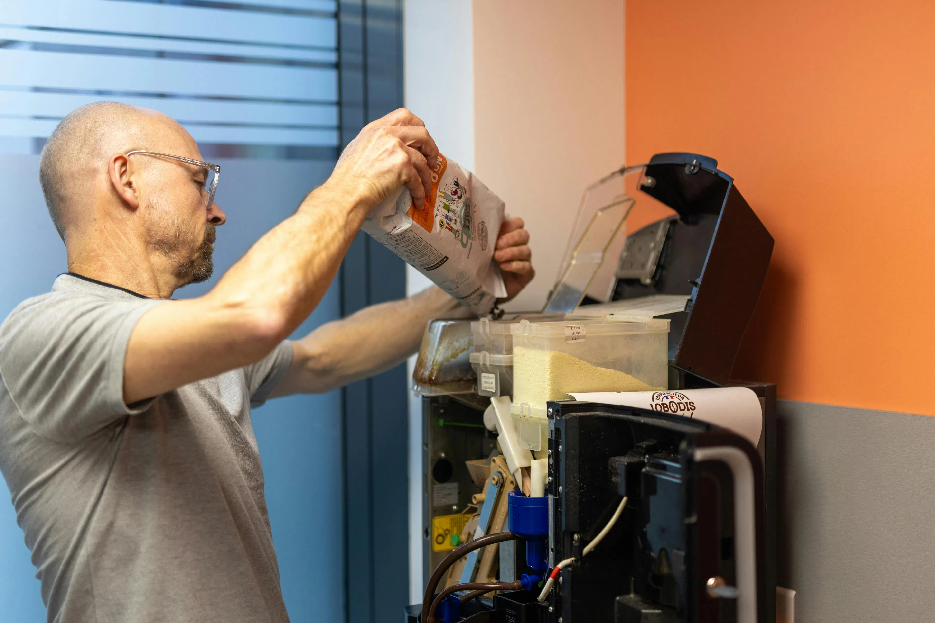 A factotum agent refilling a coffee machine