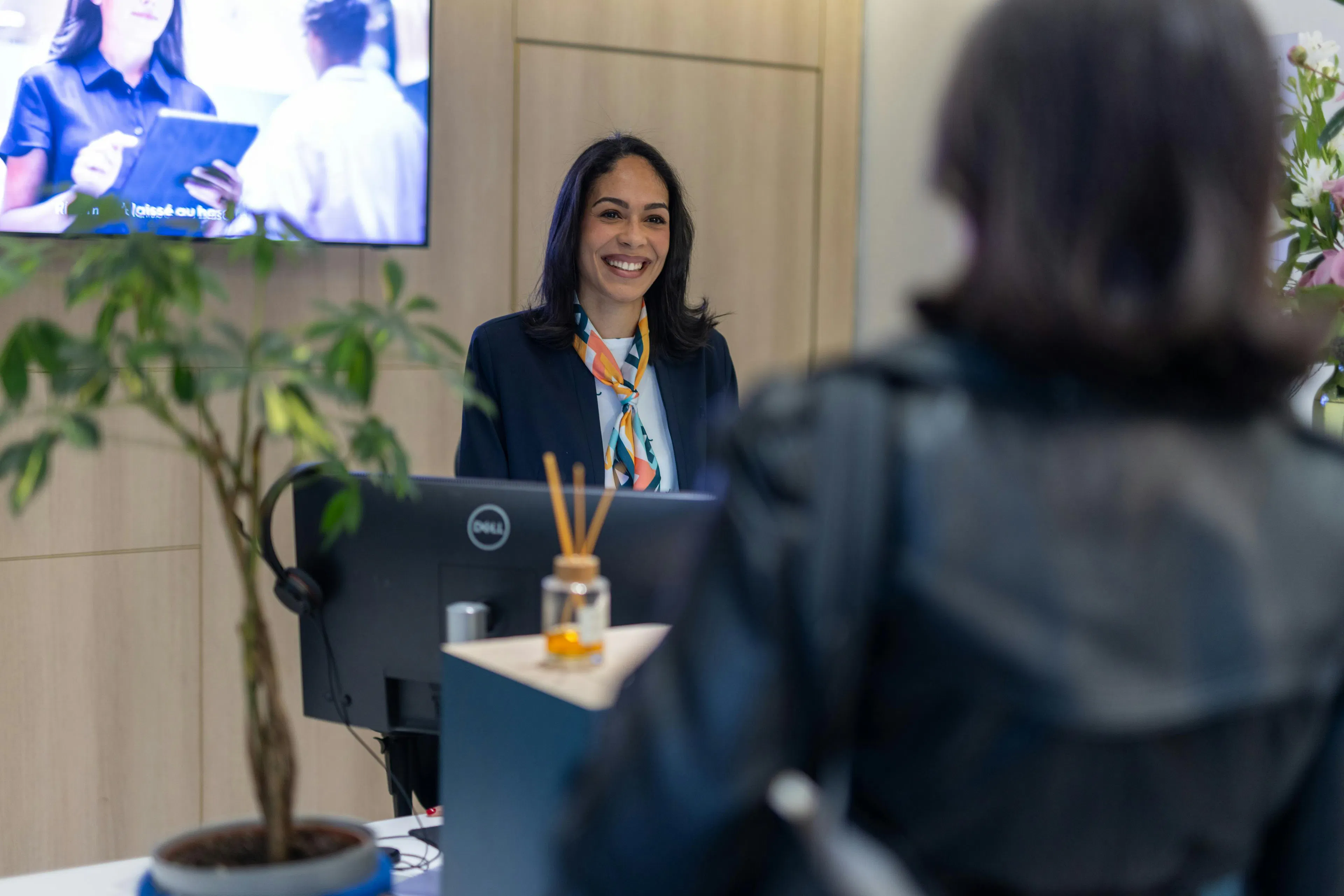 A hostess welcoming a visitor in a work environment