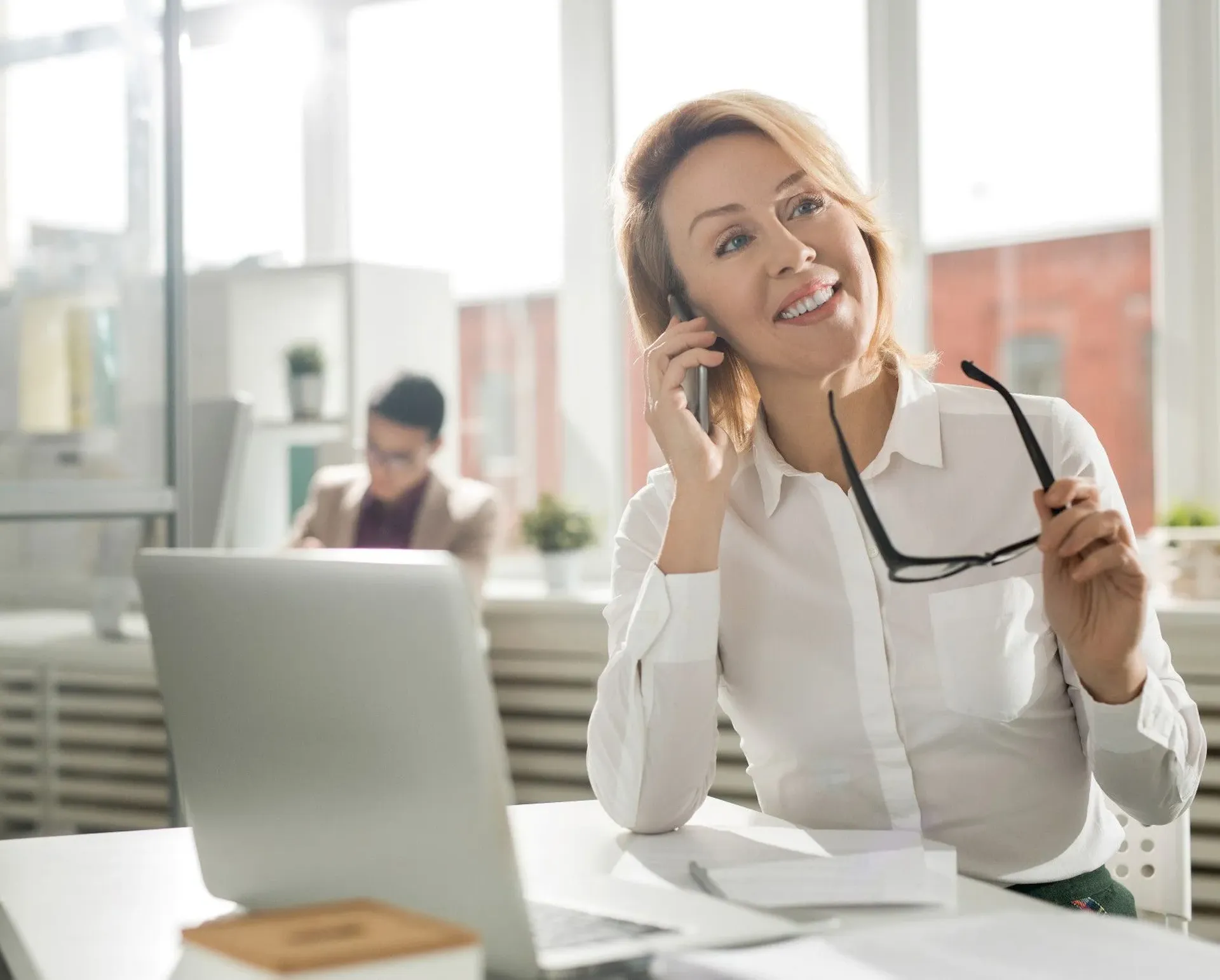 trabajadora delante de un portatil con una llamada