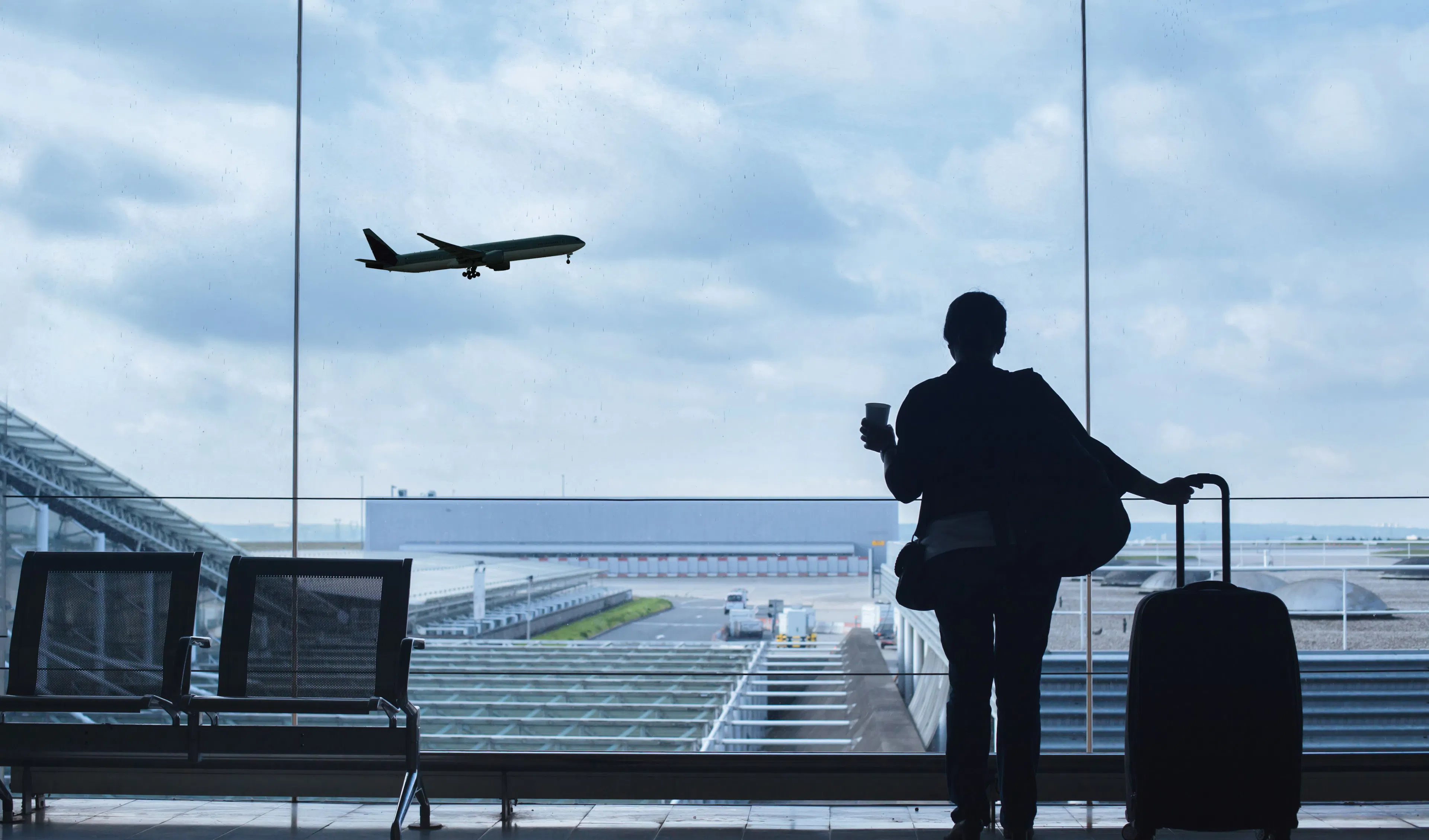 A passenger watching a plane take off at an airport