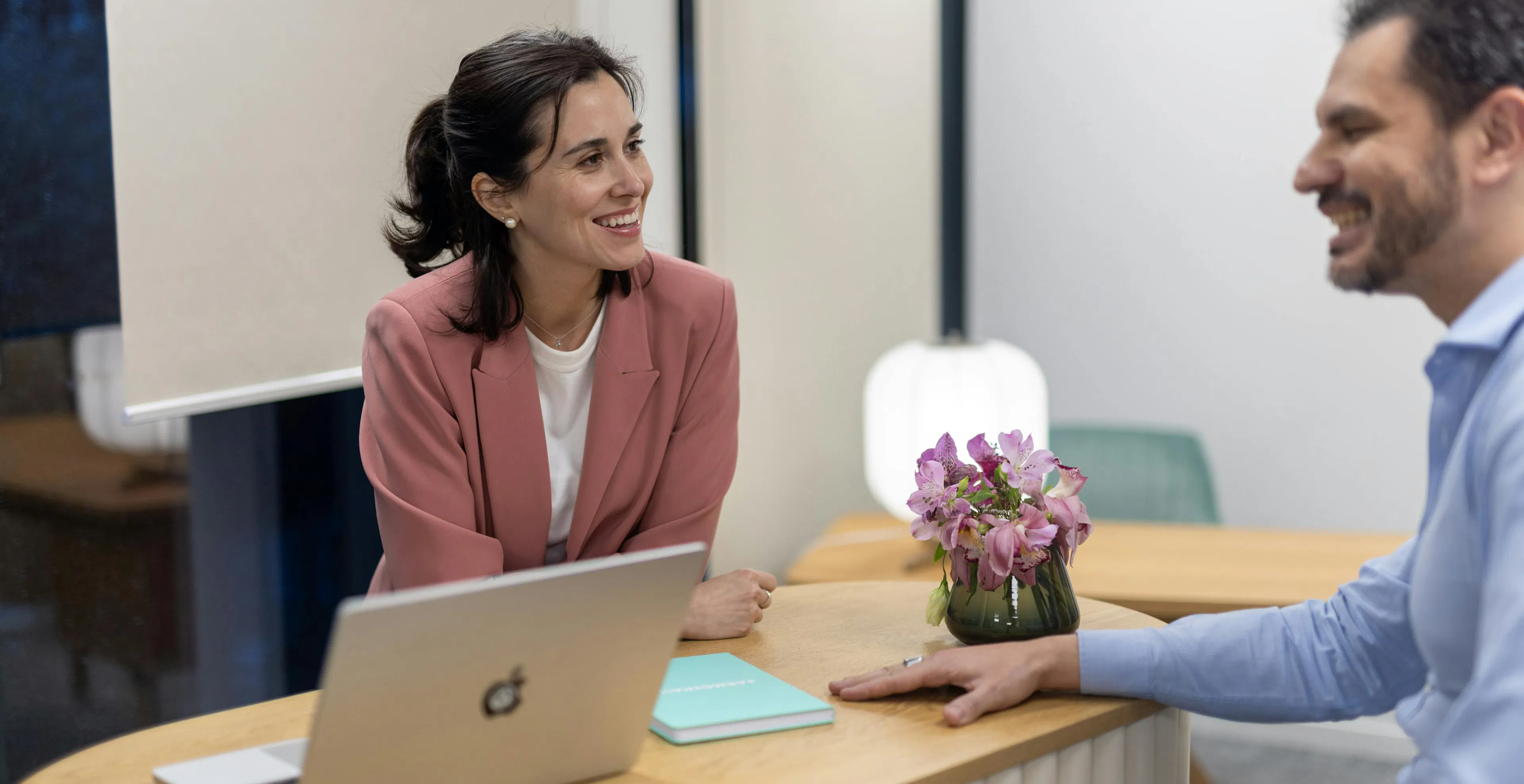 Two team members talking together around a table