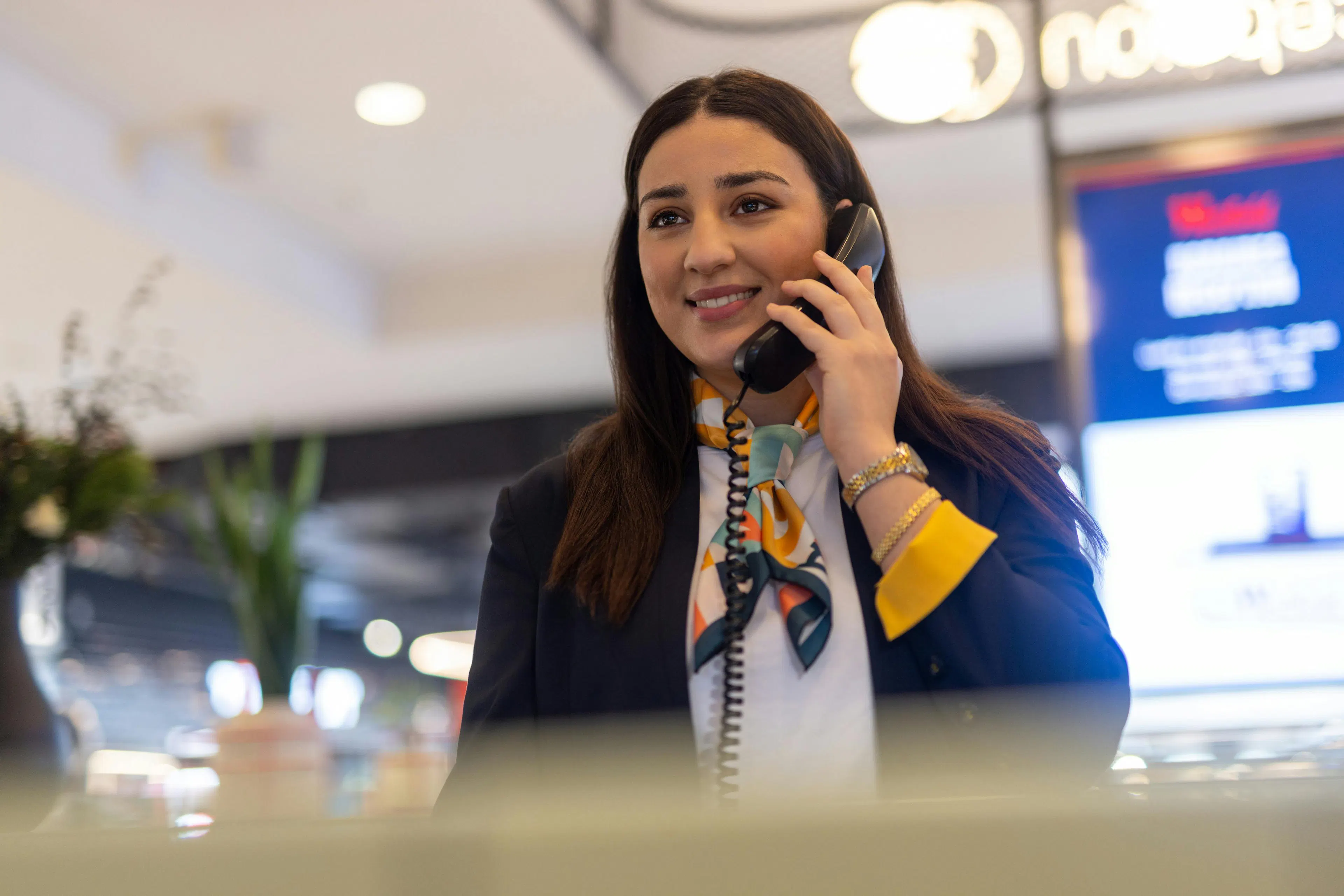 Une hôtesse d'accueil au téléphone à l'accueil d'un centre commercial