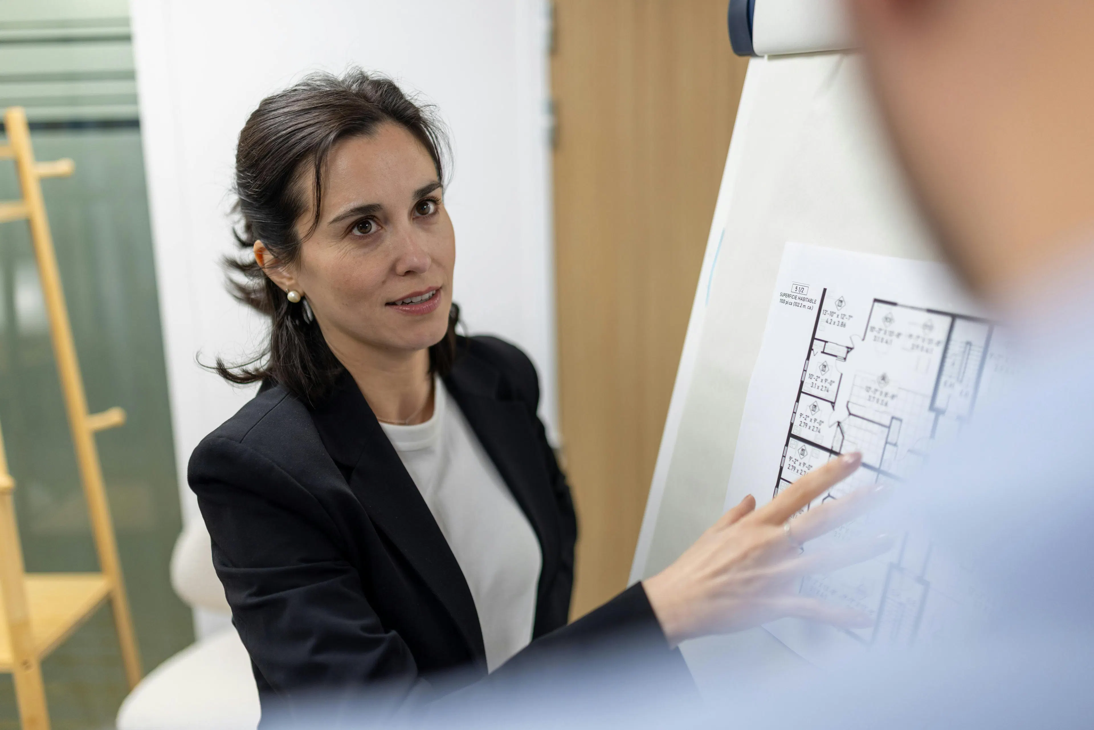 Une collaboratrice discutant avec un collaborateur autour d'un plan d'immeuble