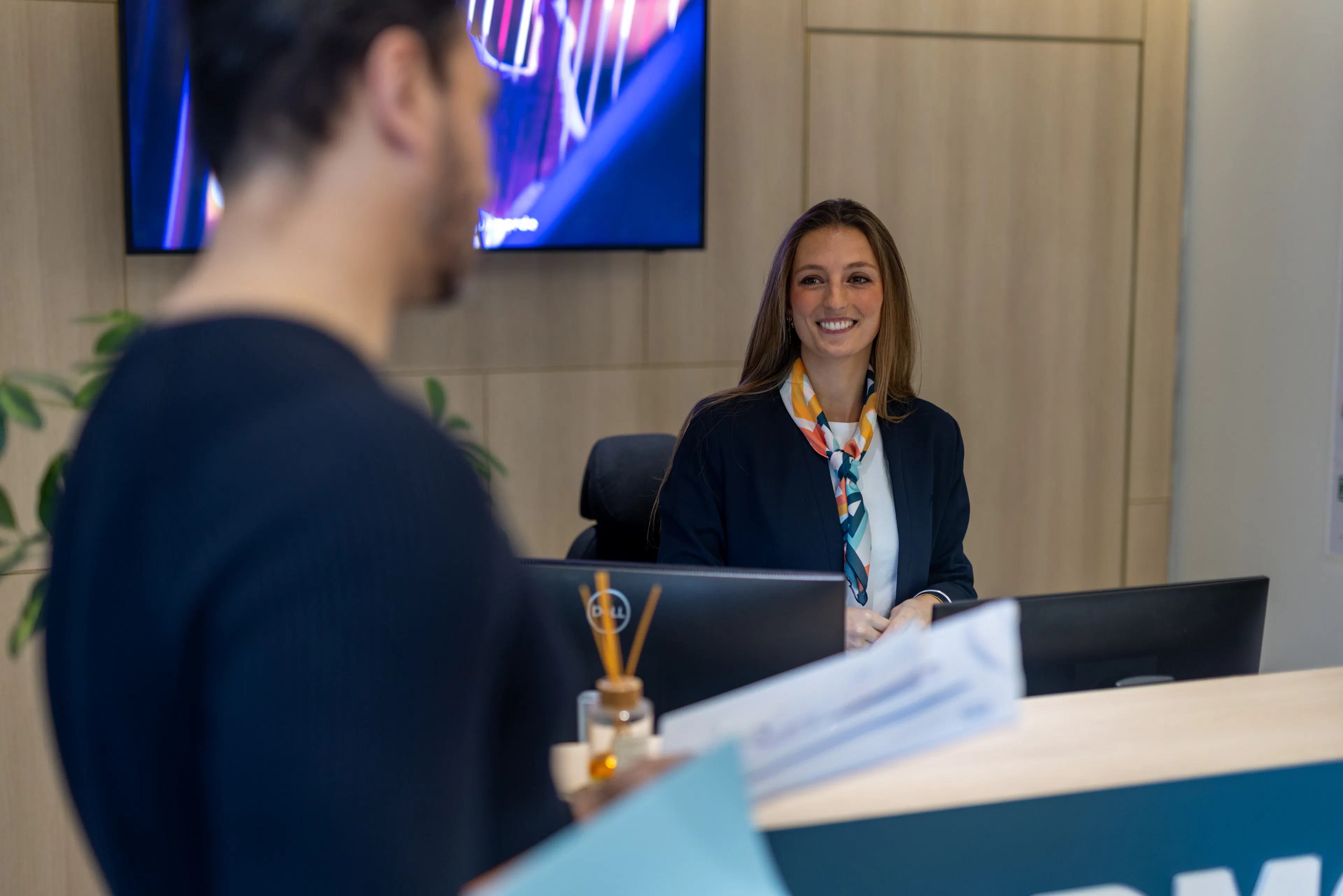Une hôtesse d"accueil accueillant un collaborateur au sein d'un environnement de travail