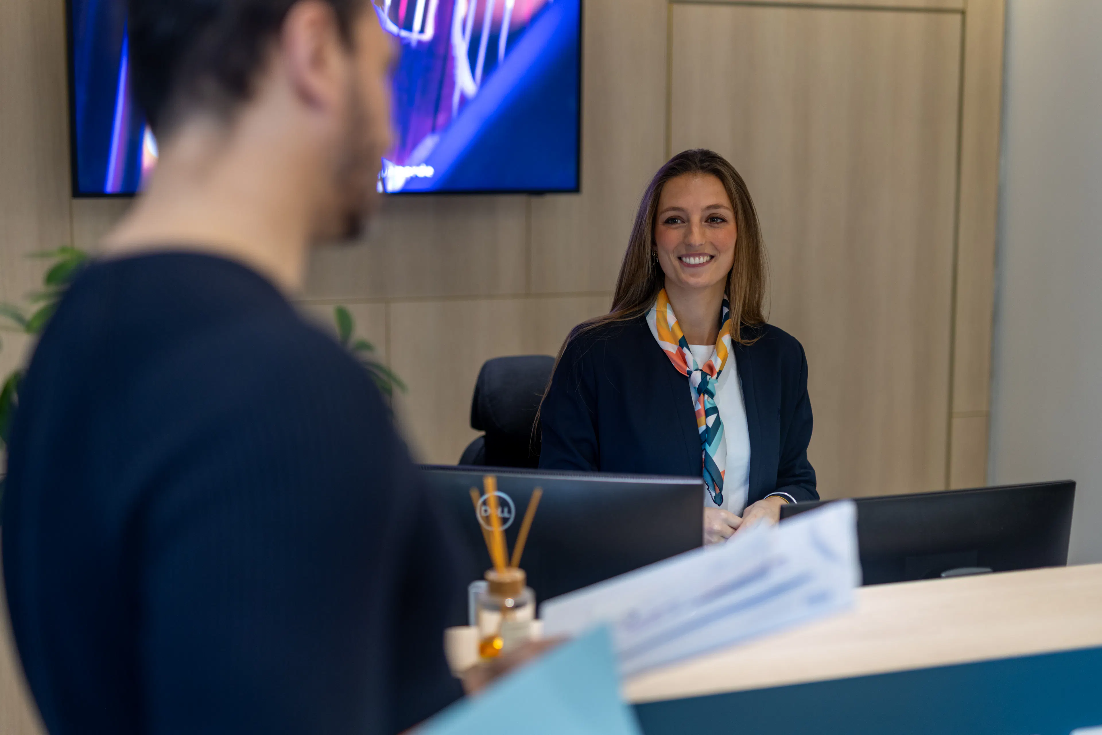 Une hôtesse d'accueil accueillant un collaborateur sur site 