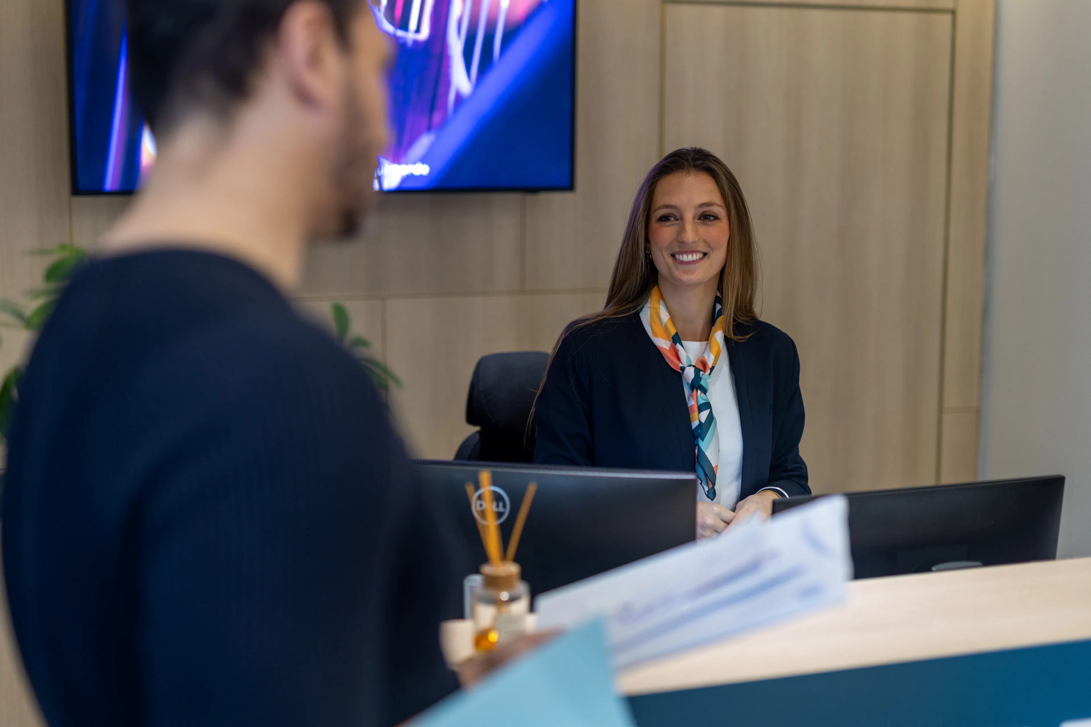 Une hôtesse d'accueil accueillant un collaborateur sur site