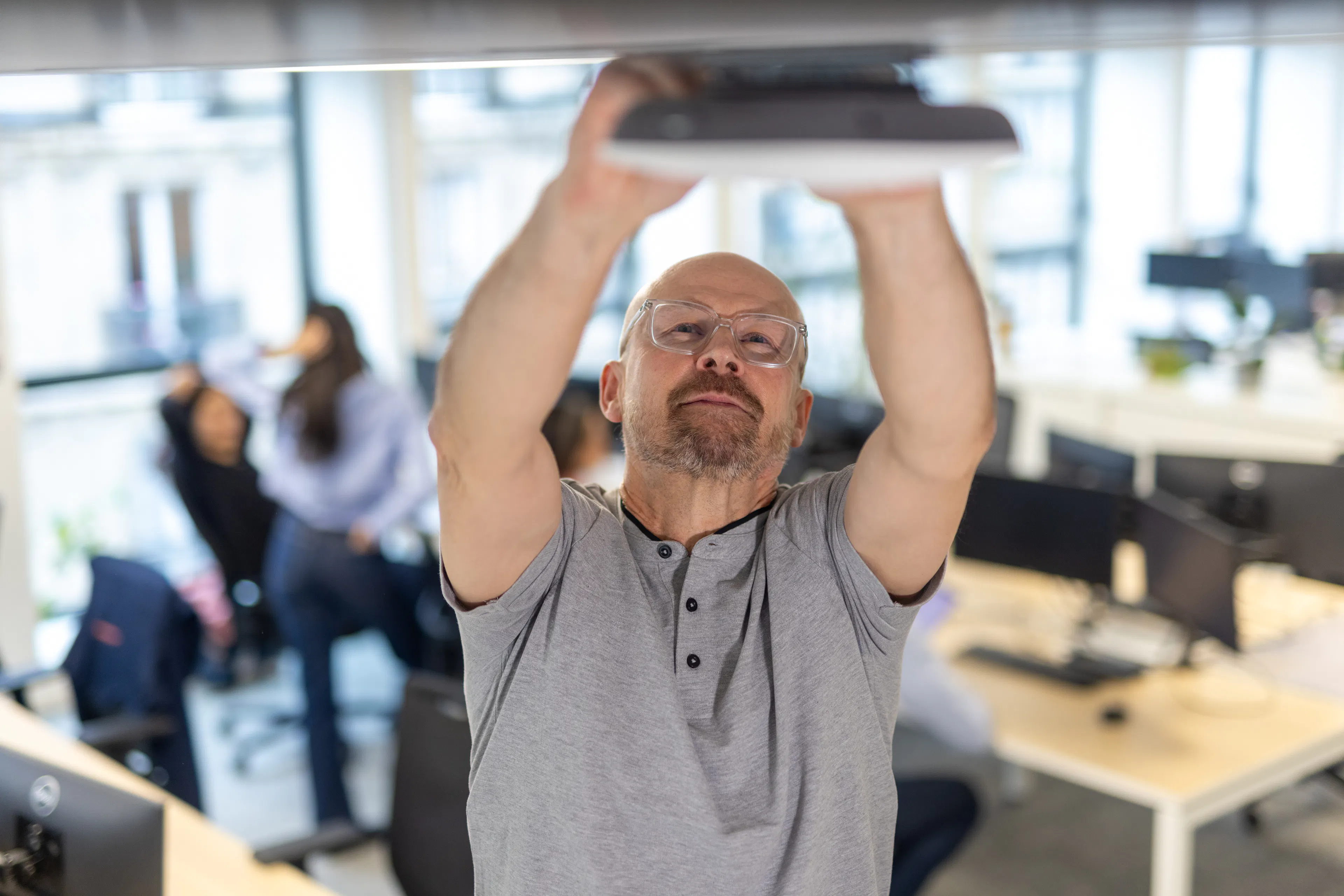 Un agent de maintenance réparant une box wifi au sein d'un environnement de travail