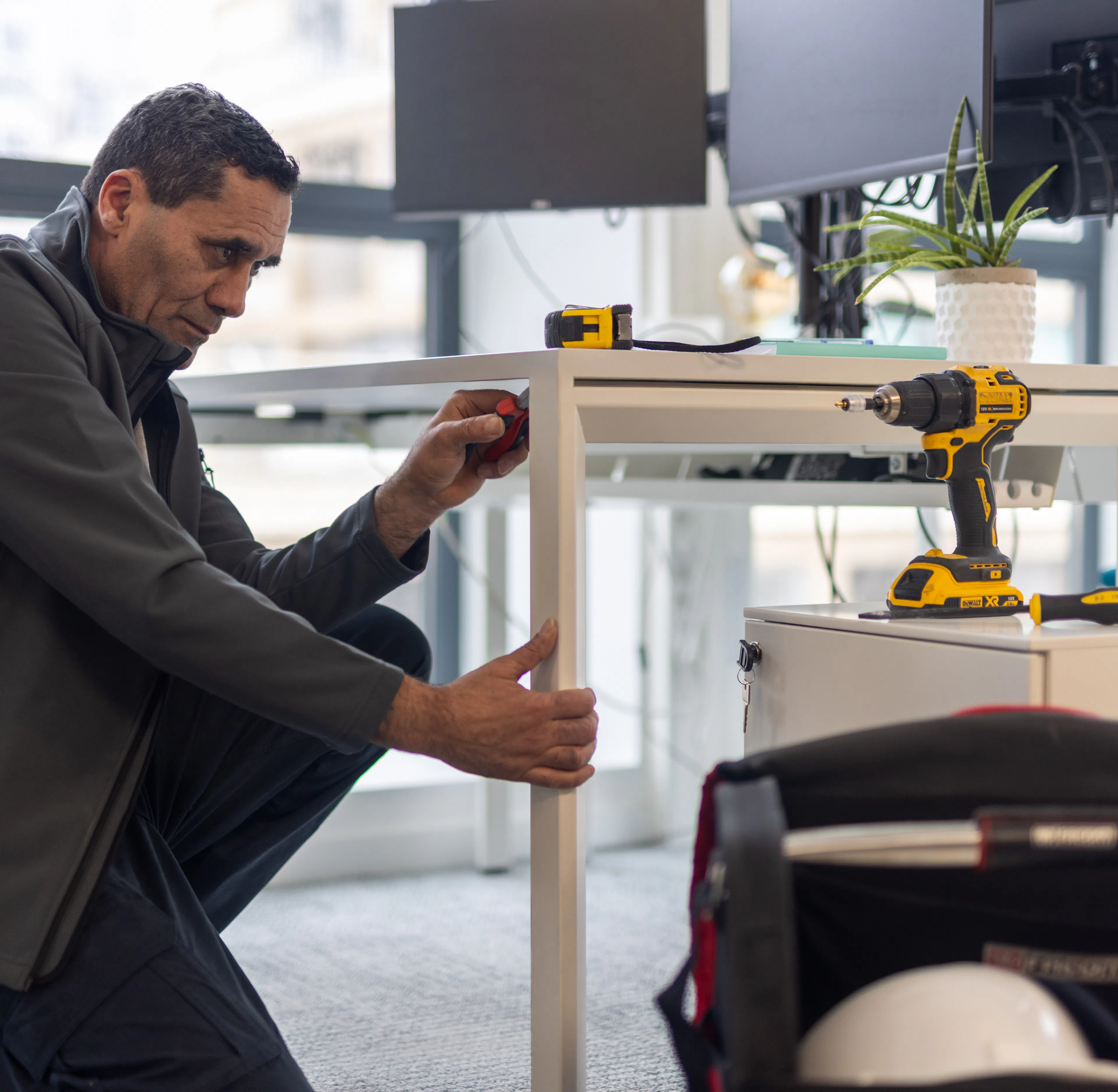 Un agent de maintenance réparant les faux plafond au sein d'un environnement de travail