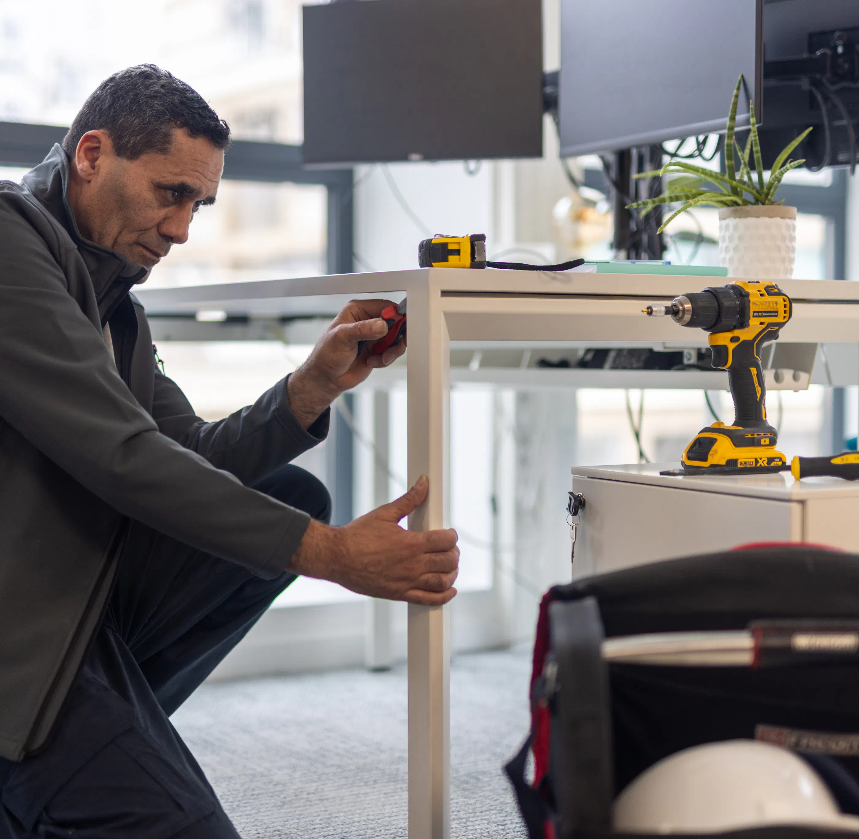Un agent de maintenance réparant les faux plafond au sein d'un environnement de travail