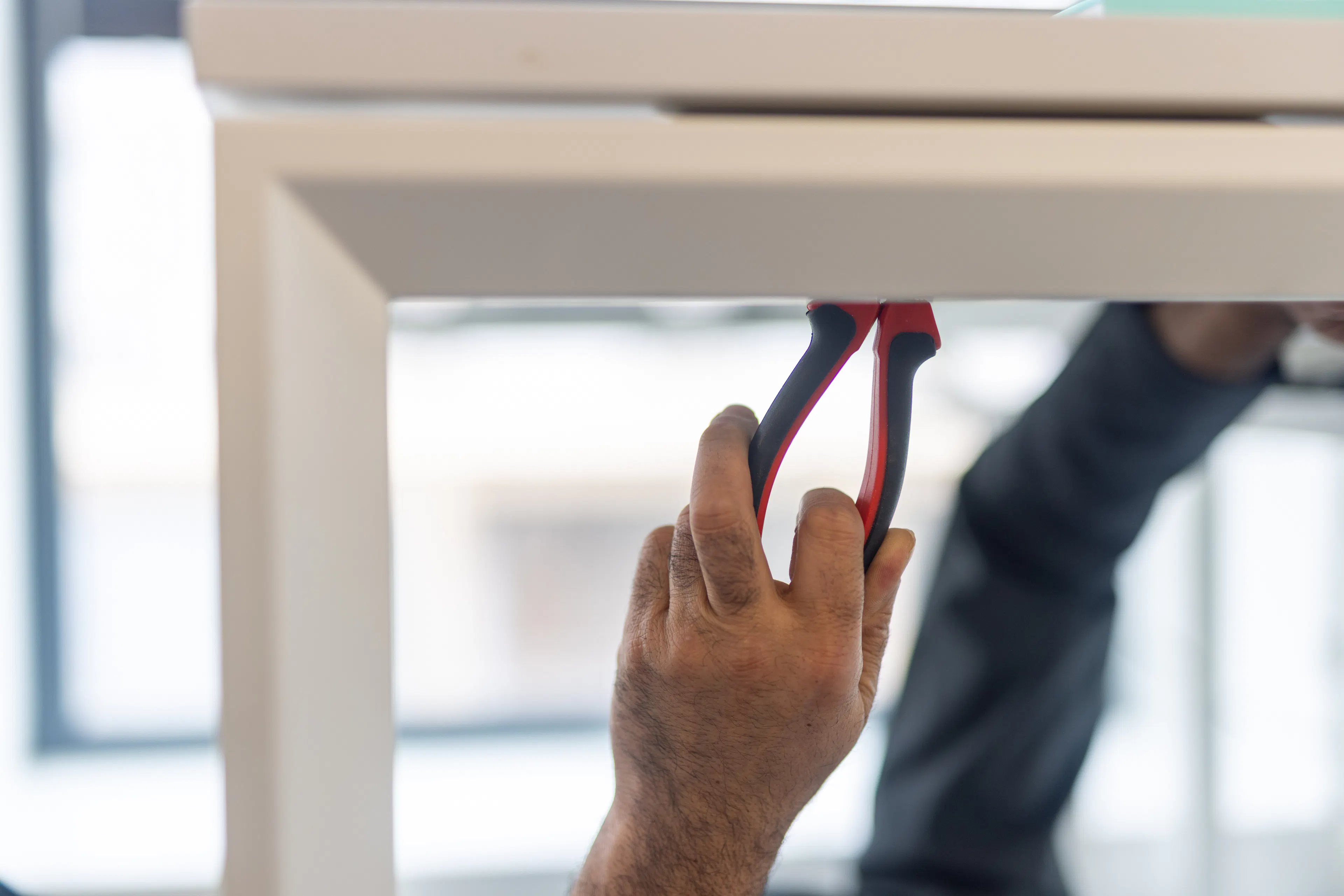 Un agent de maintenance réparant un bureau au sein d'un environnement de travail