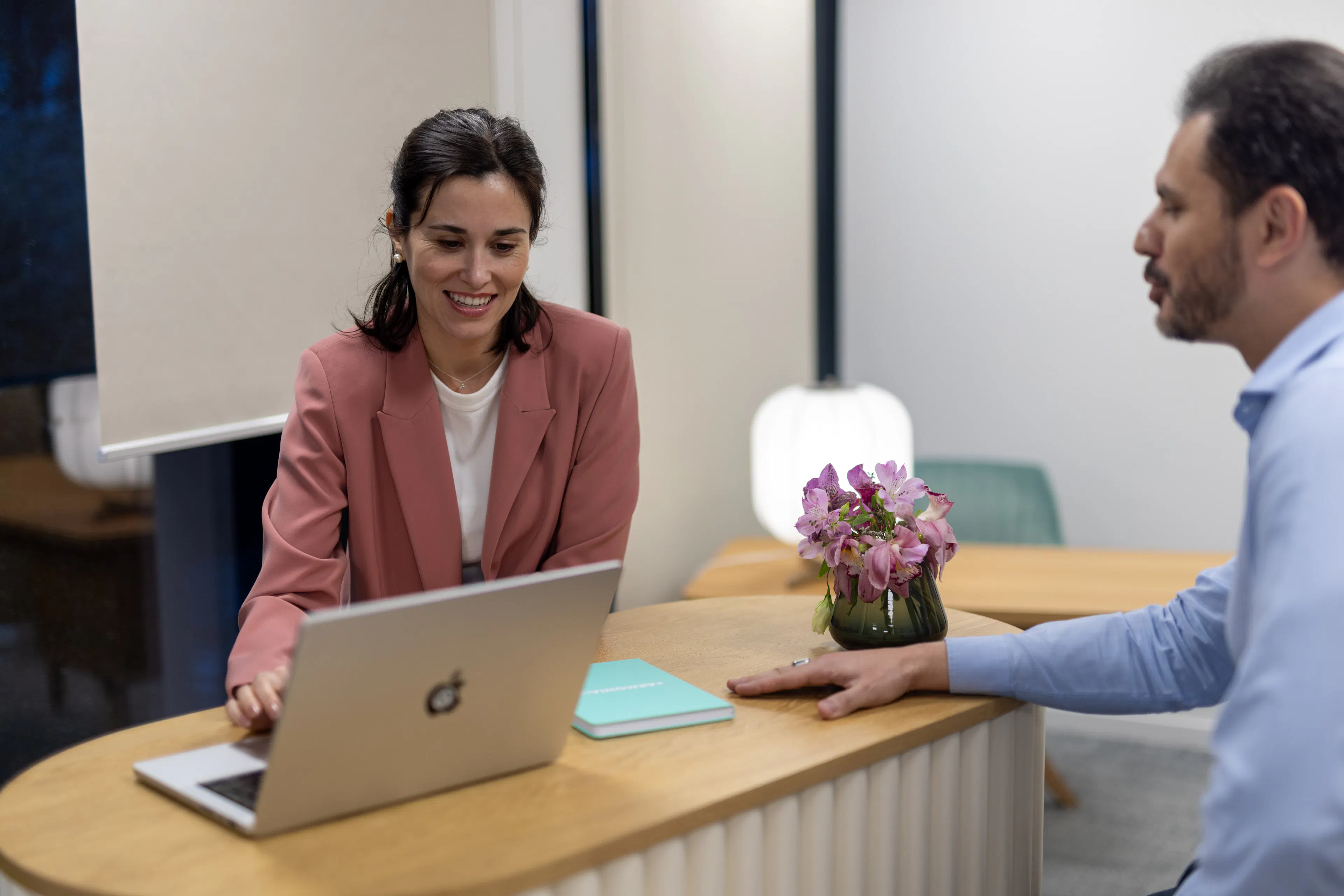 Deux collaborateurs échangeant autour d'un ordinateur