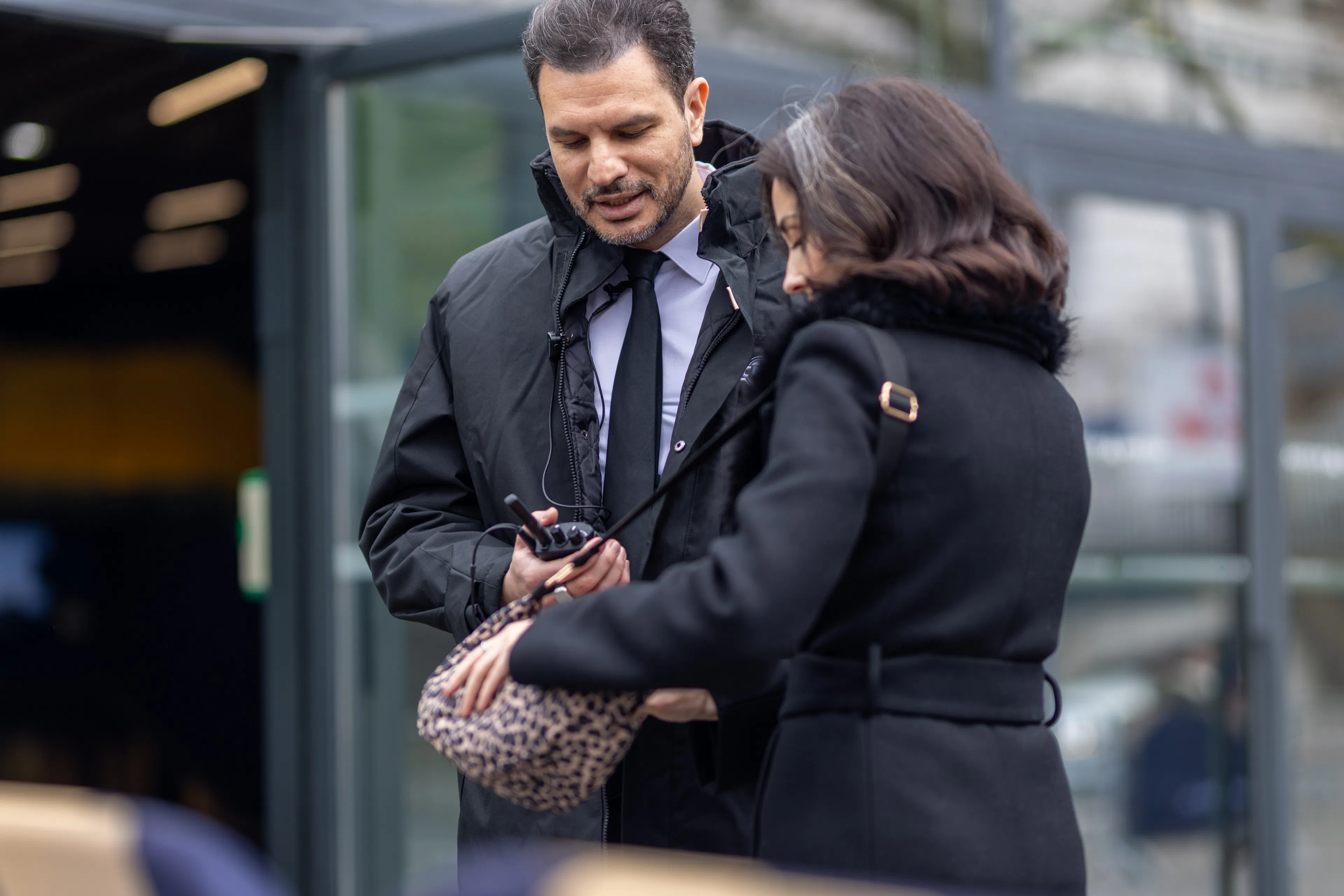 Un agent de sécurité contrôlant un visiteur à l'entrée d'un site événementiel