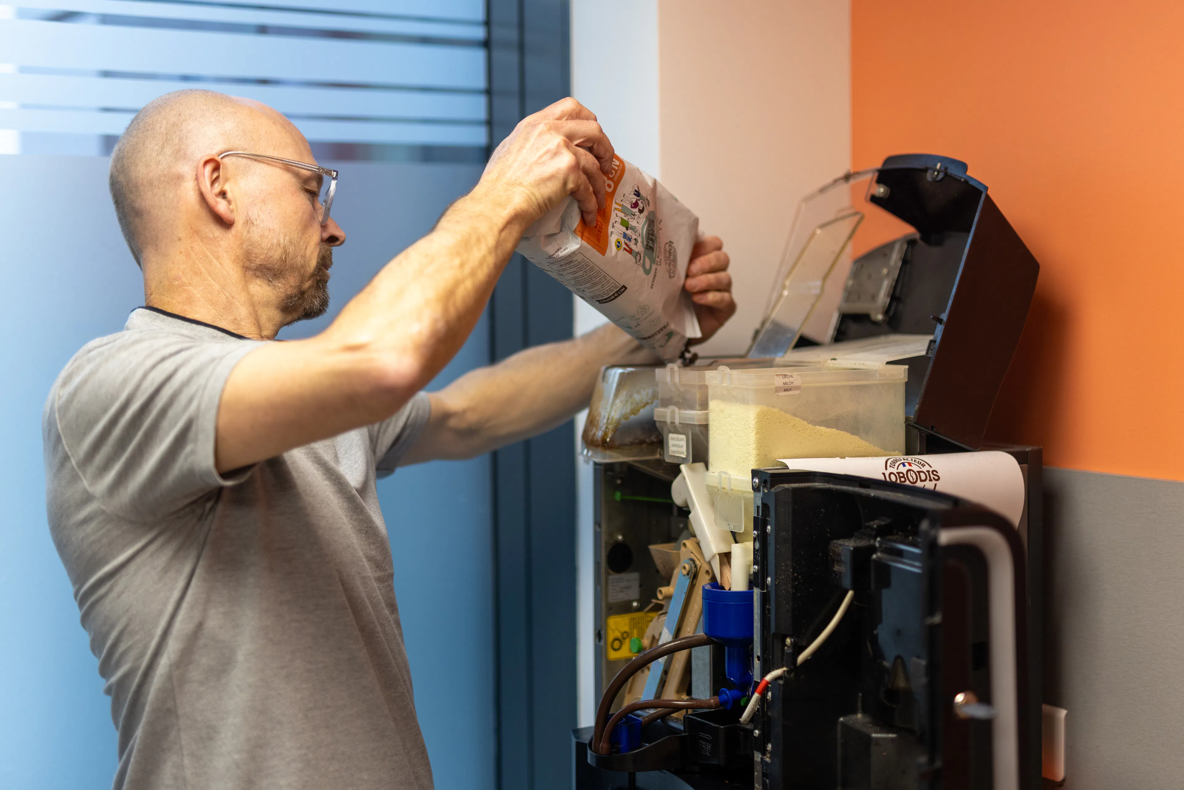 Un agent factotum remplissant une machine à café