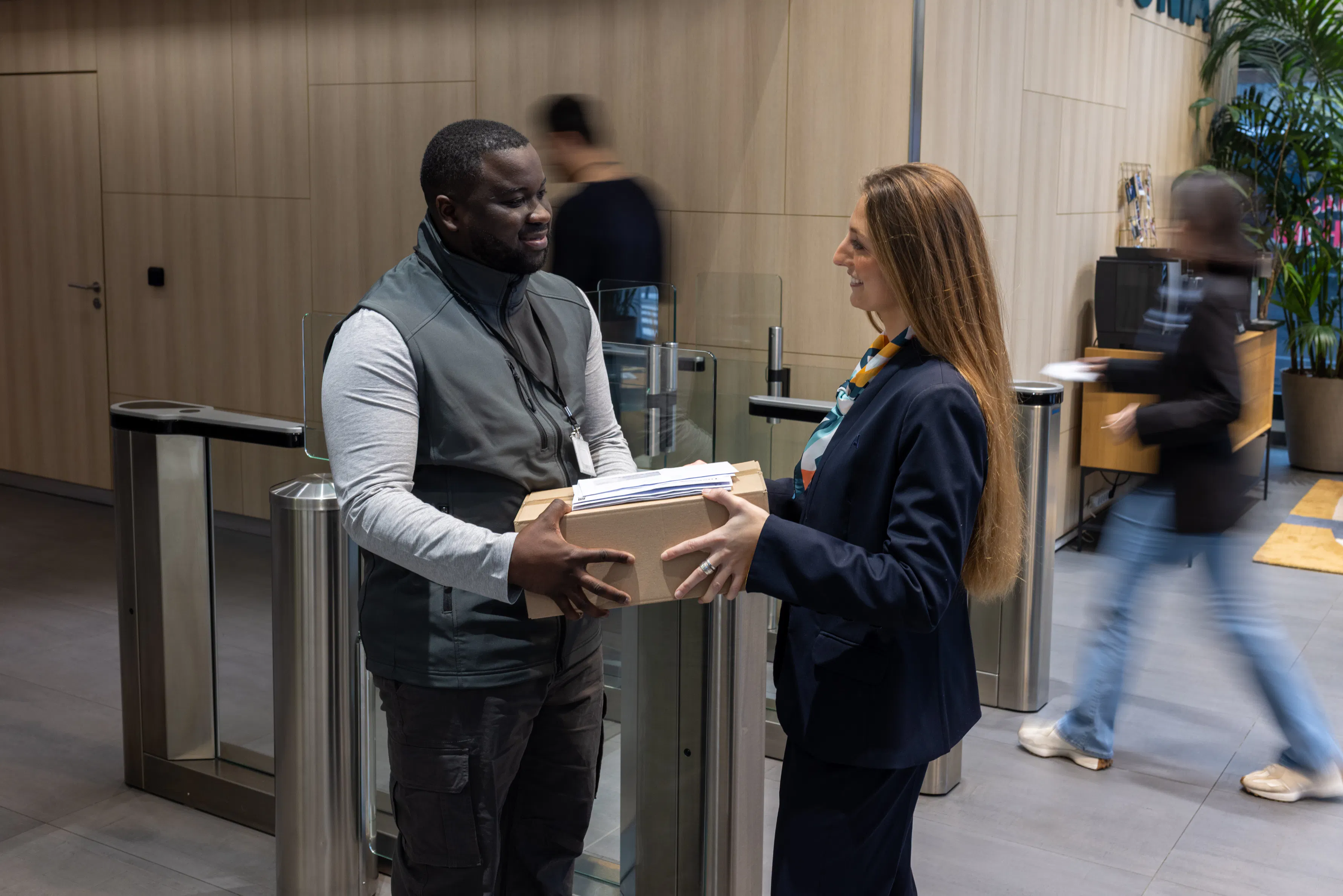 Une hôtesse d'accueil et un agent documentaire échangeant ensemble dans un environnement de travail