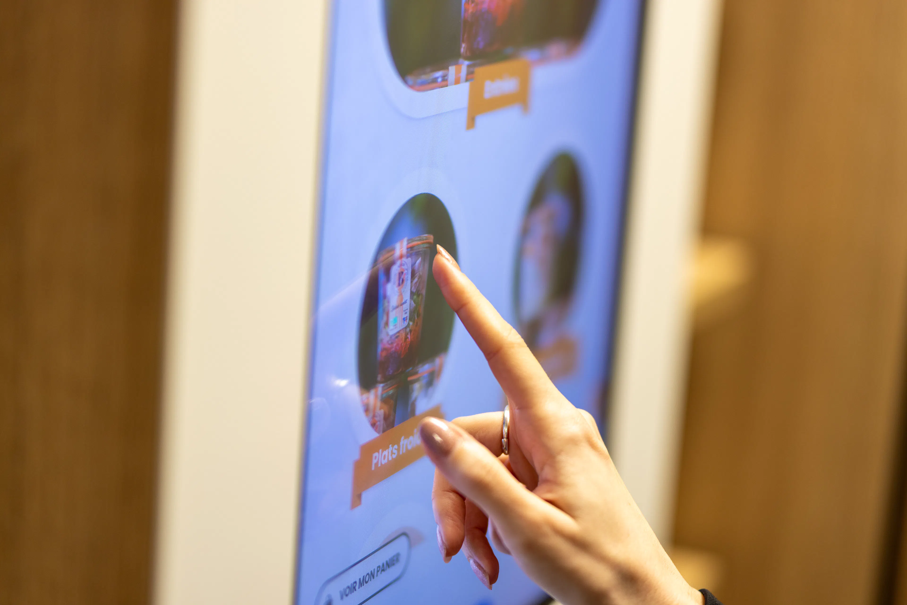 Une collaboratrice choisissant son plat sur l'interface du frigo connecté 