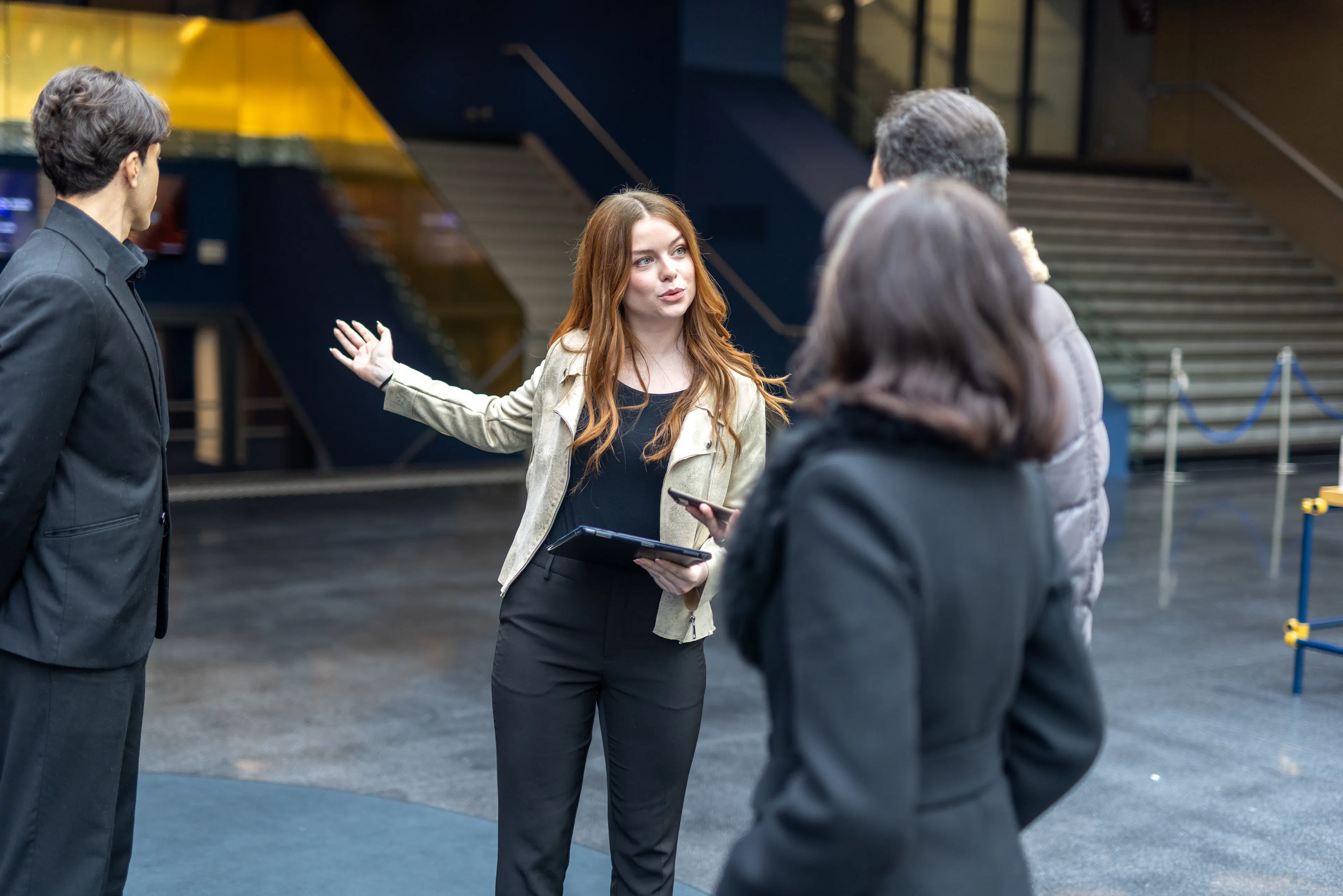 Une hôtesse accueillant des visiteurs sur un lieu événementiel